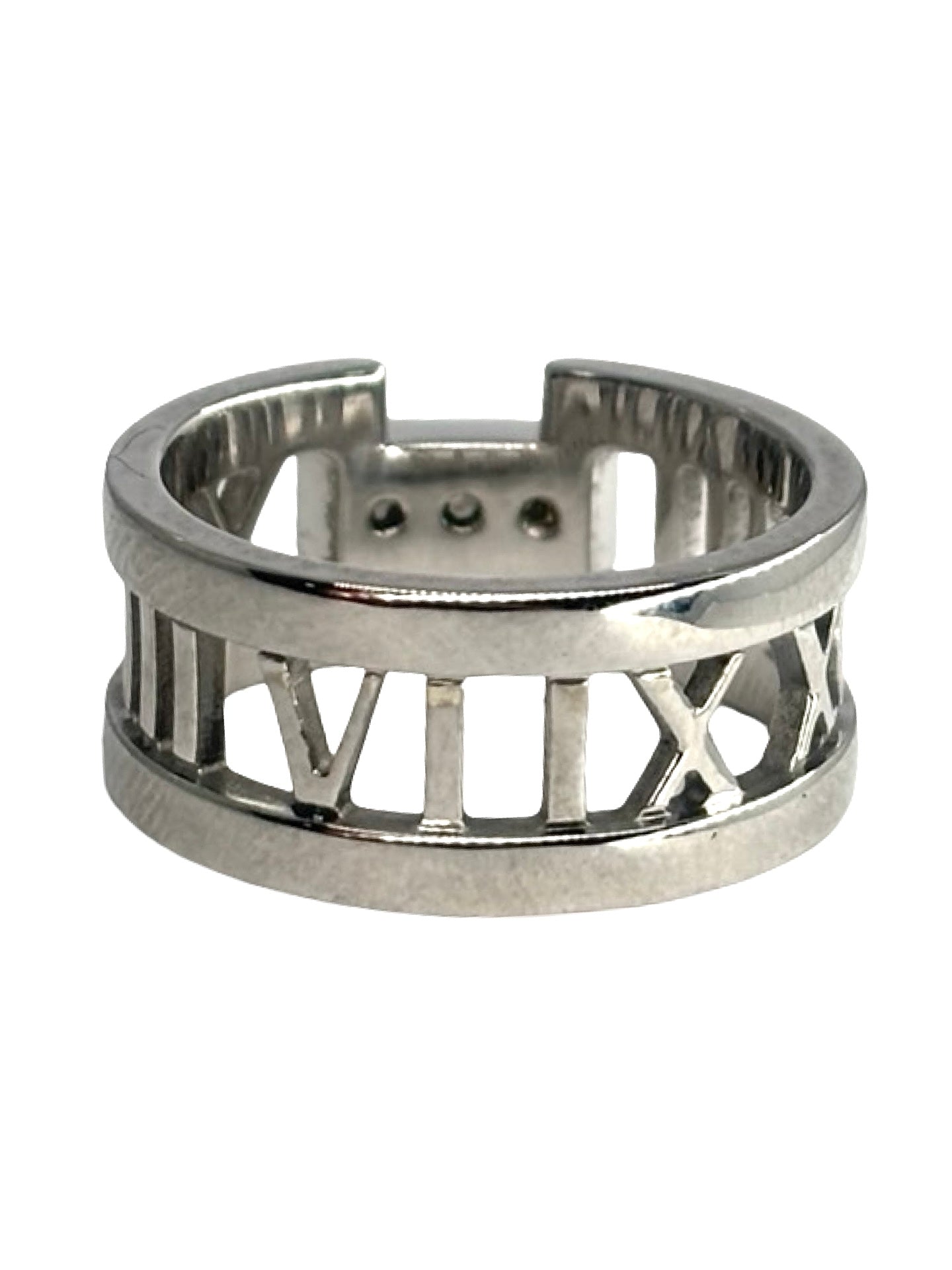 Bague Atlas ring en or blanc signée Tiffany & Co., sertie de diamants totalisant 0,15 carat. Son design graphique emblématique, inspiré des chiffres romains, allie modernité et élégance intemporelle. Un bijou raffiné et lumineux, idéal pour sublimer la main au quotidien ou marquer une occasion spéciale avec une pièce iconique de la joaillerie de luxe.