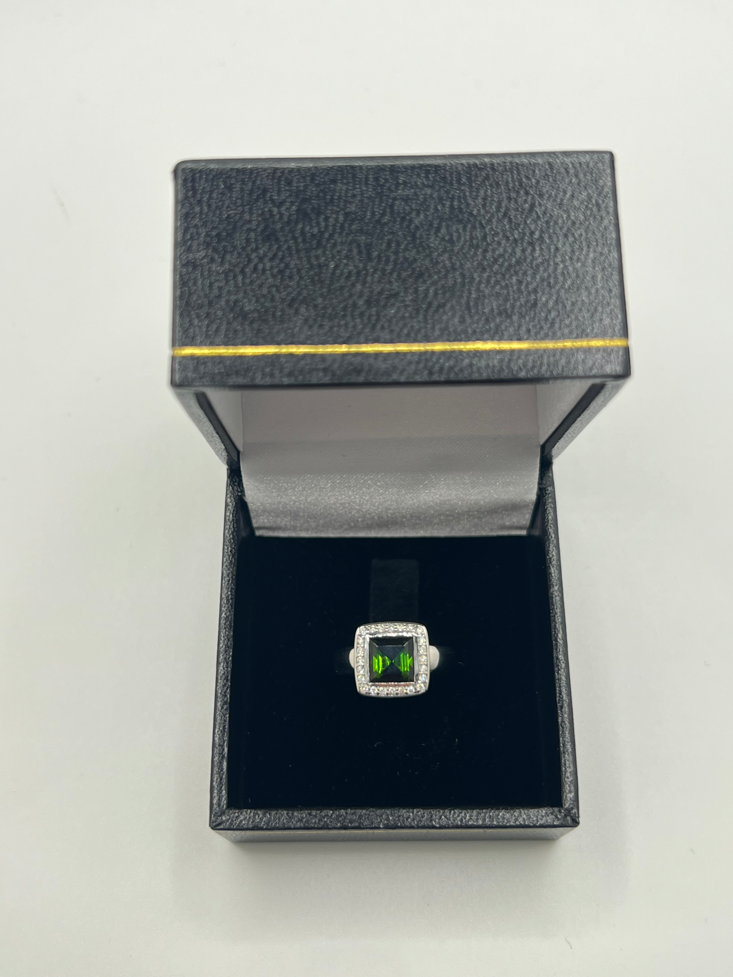 Découvrez cette élégante bague en or blanc, sertie d'une tourmaline verte de 2 carats environ, accompagnée de diamants scintillants. Ce bijou raffiné est présenté dans un écrin élégant, parfait pour offrir un cadeau précieux. Idéale pour toutes les occasions spéciales, cette bague combine la beauté de l'or blanc et l'éclat unique de la tourmaline verte, sublimée par la brillance des diamants.