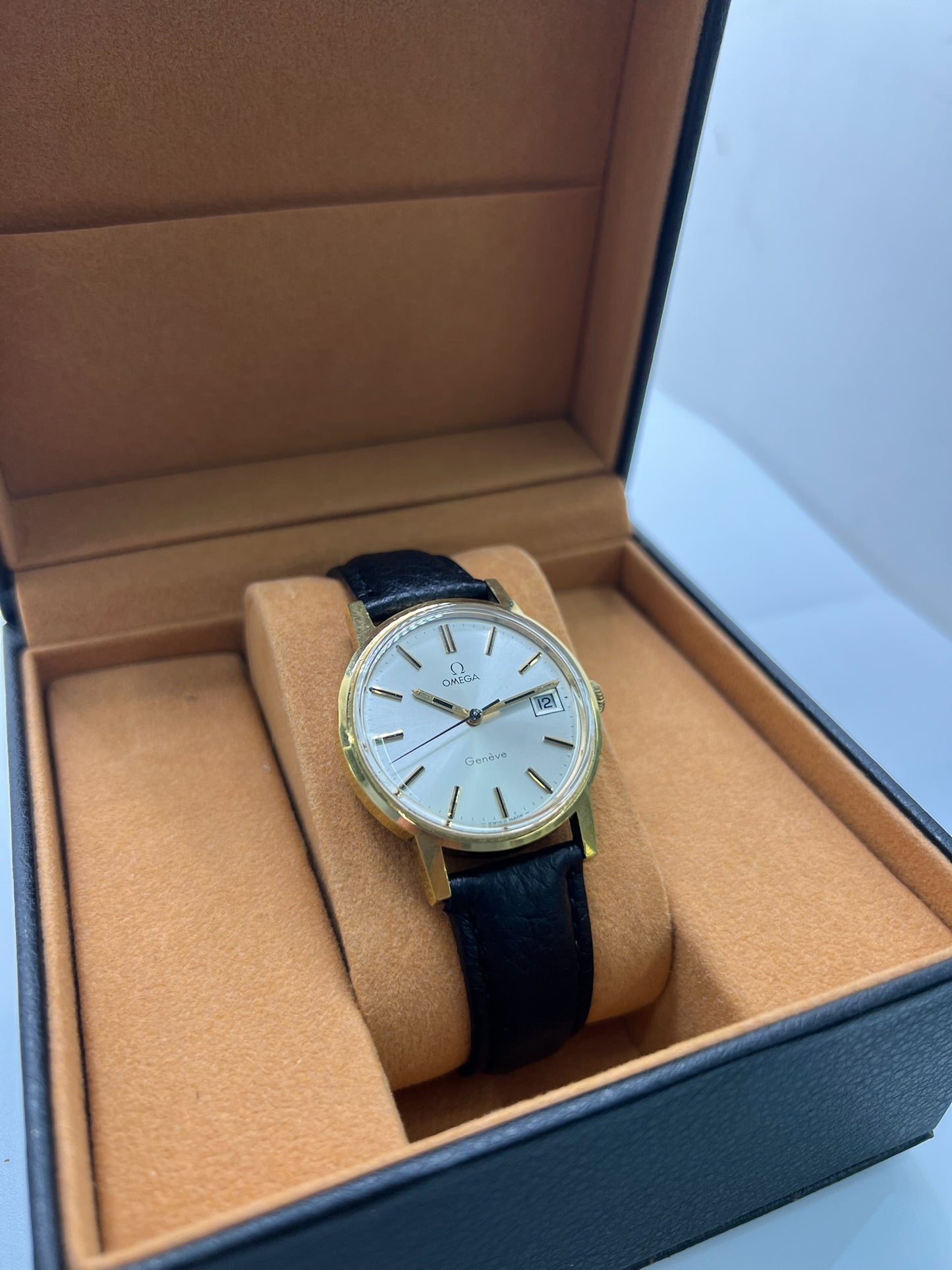 Montre Omega Genève vintage de 35 mm associant or et acier, au design classique et élégant. Cadran doré sobre offrant une lecture claire, complété par un affichage de la date. Boîtier équilibré et proportions harmonieuses, animé par un mouvement mécanique à remontage manuel révisé en interne. Bracelet en cuir noir apportant contraste et confort au poignet. Modèle en bon état d’usage, présentant des traces d’usure visibles telles que rayures, éraflures et petites marques liées à son âge et à son histoire.