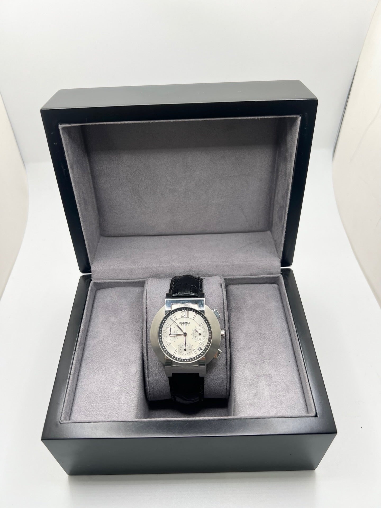 Montre Hermès Nomade Chronograph en acier avec boîtier de 39 mm et cadran blanc à index bâtons. Ce chronographe à mouvement quartz est équipé d’un verre saphir, d’un affichage de la date et d’un bracelet en cuir de crocodile gris avec boucle déployante en acier. Son design élégant et sportif reflète le savoir-faire horloger de la maison Hermès. Modèle unisexe d’occasion en très bon état, alliant confort, précision et raffinement au quotidien.