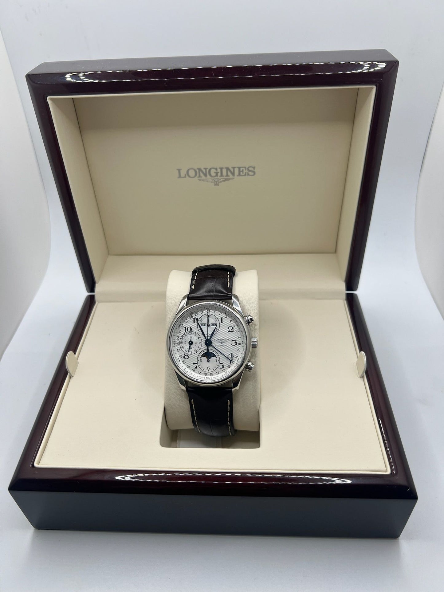 La Longines Master Collection L2.673.4.78.3 allie tradition horlogère et élégance. Ce chronographe automatique affiche un calendrier complet avec phase de lune, dans un boîtier en acier de 40 mm. Son cadran argenté et son bracelet en cuir marron font de cette montre un choix raffiné pour les amateurs de complications horlogères.