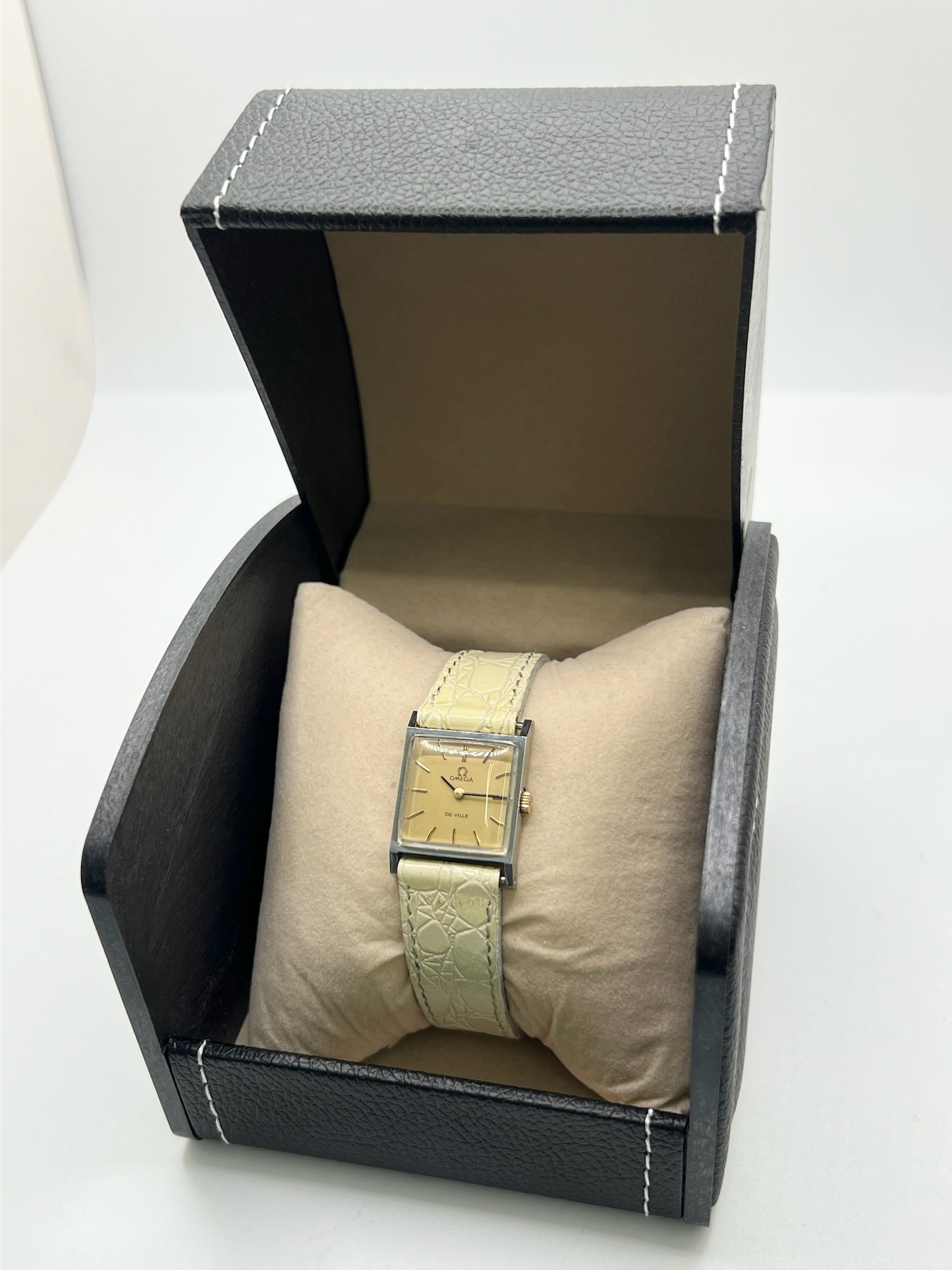 Montre Omega De Ville 511.087 vintage pour femme en acier, fabriquée en 1966. Cette montre élégante est dotée d'un cadran champagne avec index bâtons, d'un mouvement à remontage manuel calibre 620 et d'un verre en plexiglas. Elle est montée sur un bracelet en cuir beige avec boucle ardillon en acier. Son format de 19,5 mm lui confère une allure raffinée et intemporelle. Montre de collection en très bon état d'occasion, révisée et prête à être portée.
