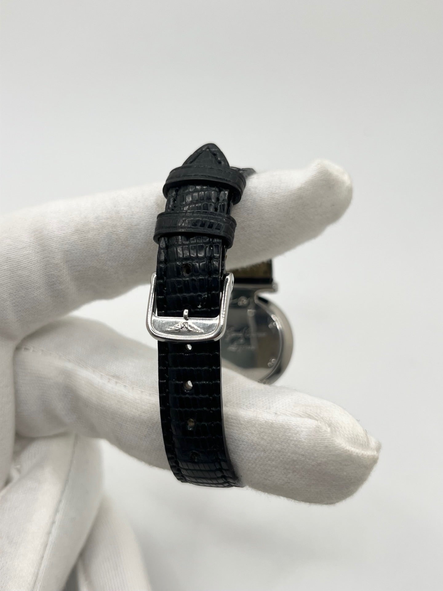 Montre Longines La Grande Classique L4.209.4 pour femme en acier avec bracelet en cuir de lézard noir. Ce modèle à mouvement quartz est doté d'un boîtier de 24 mm, d'un cadran blanc épuré sans chiffres, d'une lunette en acier et d'un verre saphir. Élégante et intemporelle, cette montre de luxe d'occasion est en très bon état avec de légères traces d'usure. Son design raffiné en fait un choix idéal pour un usage quotidien ou une collection horlogère.