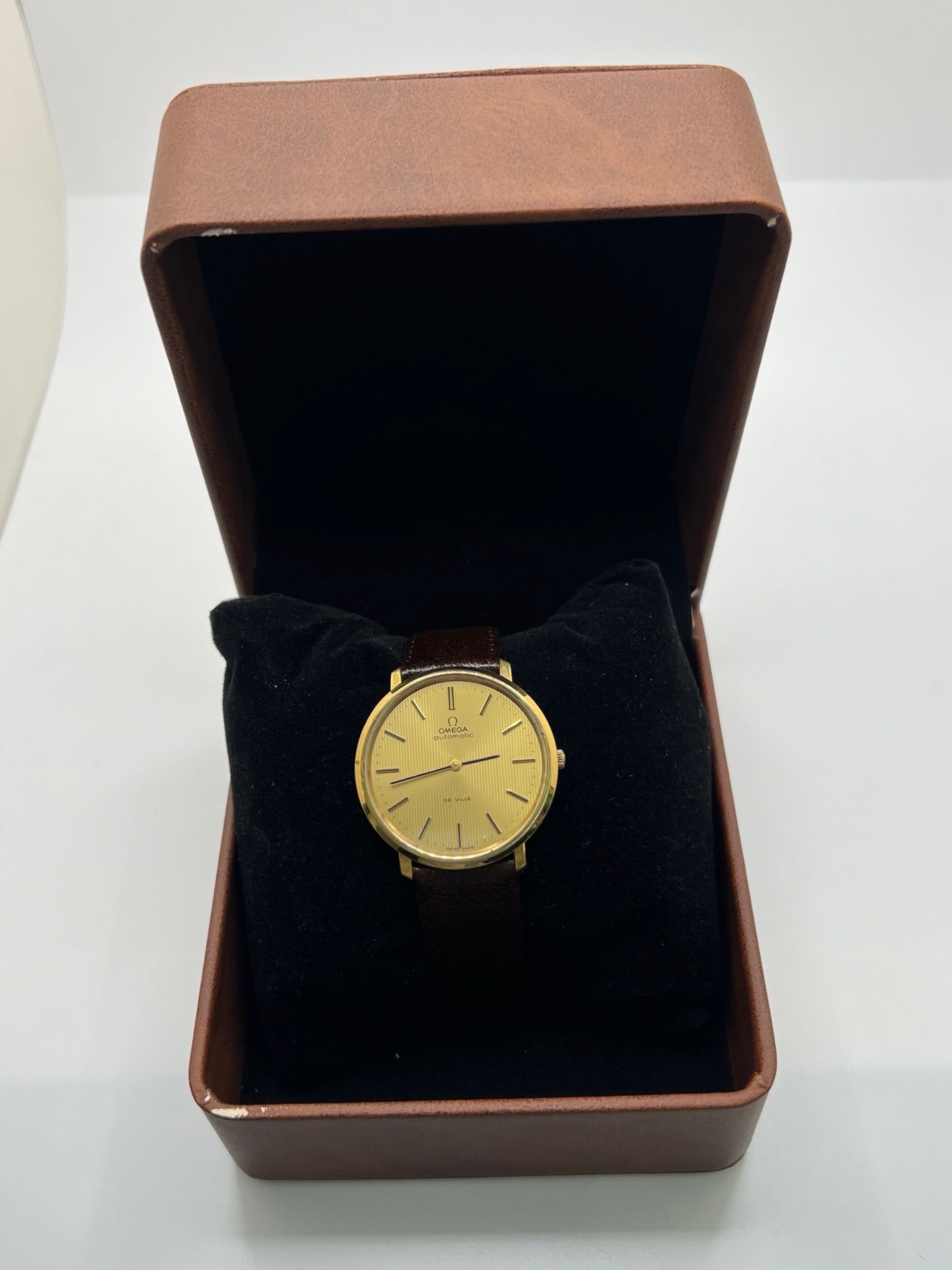 Montre Omega De Ville référence 151.0039 vintage de 1973 en acier avec mouvement automatique calibre 711, cadran doré et bracelet en cuir noir. Ce modèle homme ou unisexe de 35,5 mm présente un design élégant et intemporel. Montre d’occasion en très bon état, révisée en interne le 13 mars 2026, avec légères traces d’usure discrètes. Pièce classique de collection sans coffret ni papiers d’origine.