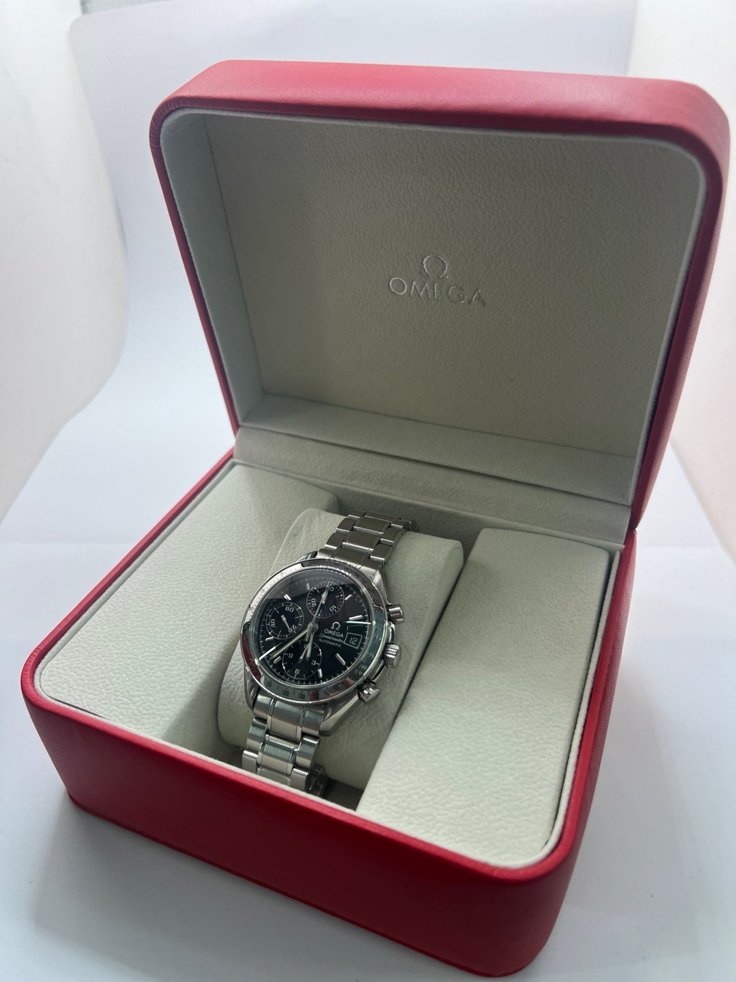 Montre Omega Speedmaster Date référence 3513.50 en acier, chronographe automatique avec boîtier de 39 mm et bracelet en acier assorti. Cadran noir sobre sans chiffres, protégé par un verre saphir, avec affichage de la date et fonctions chronographe. Modèle étanche 5 ATM, animé par le calibre automatique 1152 offrant 44 heures de réserve de marche. Montre homme élégante et sportive, emblématique de la collection Speedmaster.