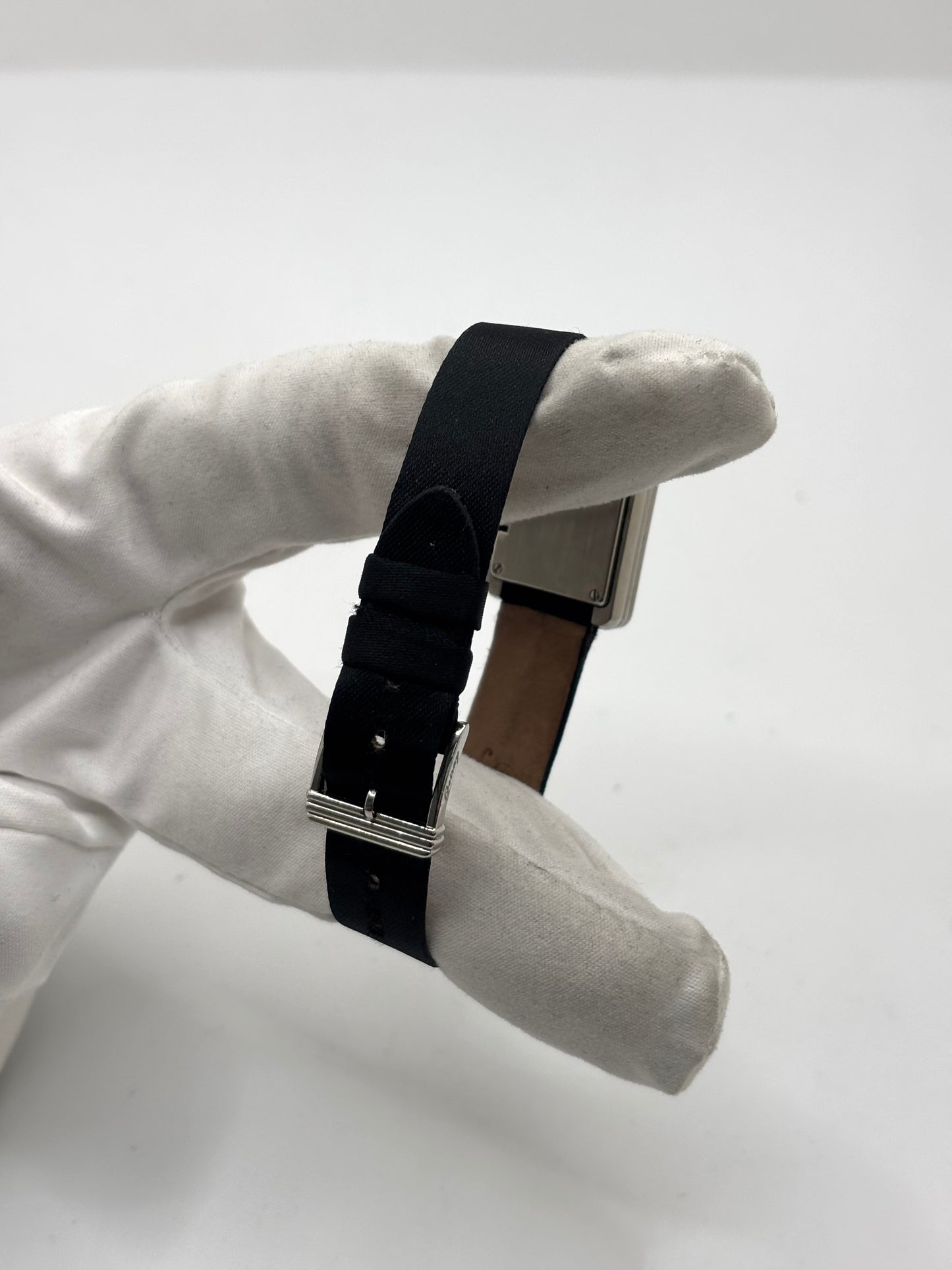 Montre Poiray Ma Première petit modèle en acier avec boîtier de 21,30 × 18,20 mm, cadran blanc épuré sans chiffres et verre minéral. Animée par un mouvement quartz, cette montre femme est équipée de son bracelet textile noir et de sa boucle ardillon d'origine en acier. Révisée, en excellent état et garantie 1 an, cette montre de luxe au style intemporel incarne l'élégance parisienne et le savoir-faire horloger de la maison Poiray.