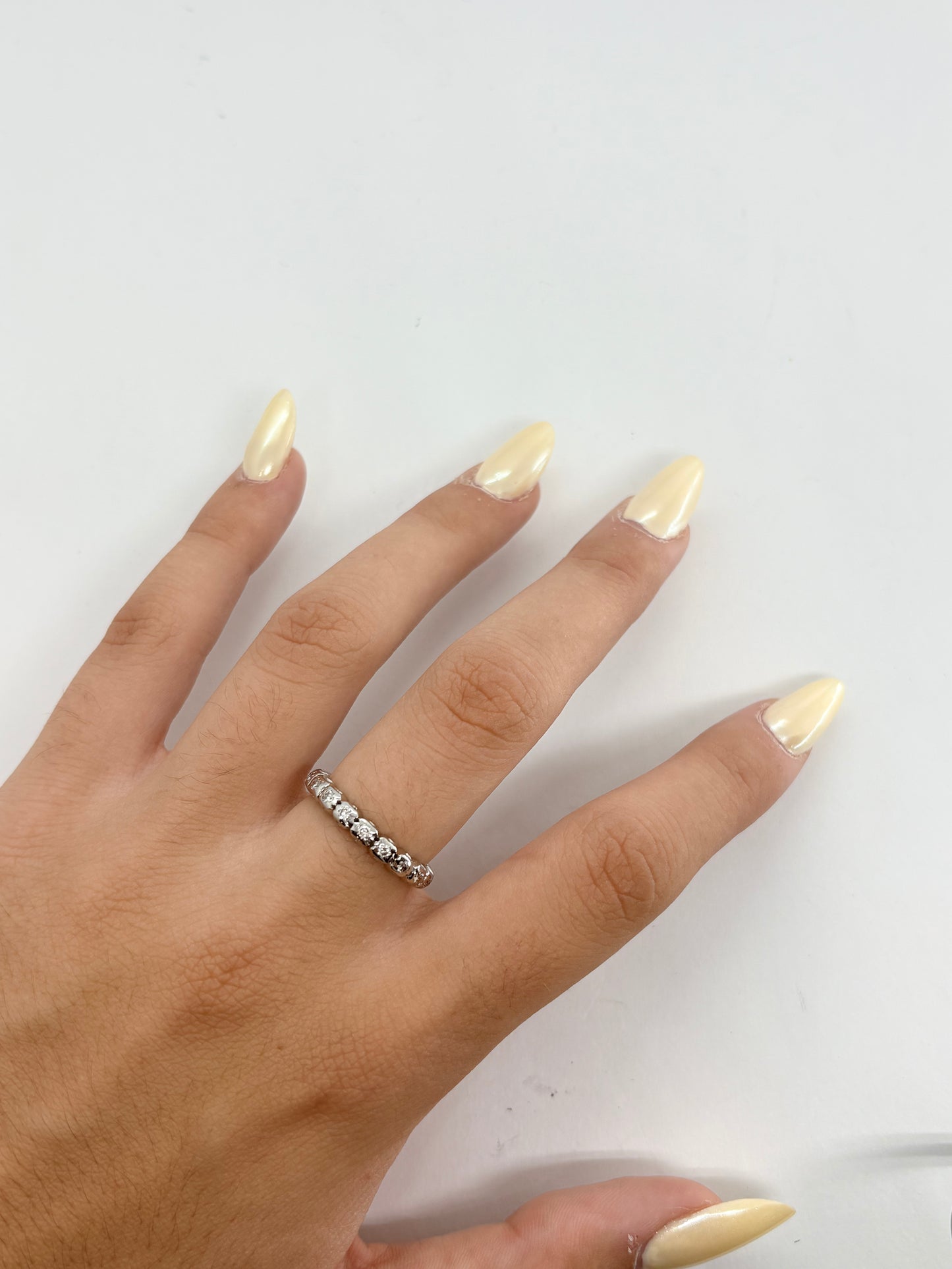Alliance tour complet en or blanc 18K avec anneau serti de diamants pour un poids total de 0,40 carat. Son tour d'éternité scrupuleusement travaillé offre une brillance continue tout autour du doigt, mettant en valeur l'éclat pur des pierres et la finesse de la monture. Cette alliance de seconde main est en très bon état, contrôlée en interne et livrée dans son écrin. Un bijou de joaillerie classique et intemporel disponible à Paris.