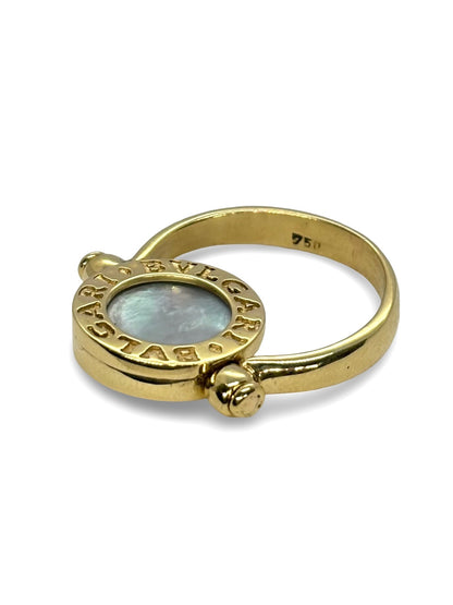Raffinée et originale, cette bague réversible signée Bulgari est façonnée en or jaune 18 carats. Elle révèle deux facettes précieuses : une face en nacre lumineuse et une autre en onyx profond, offrant deux styles en un seul bijou. Symbole du design italien audacieux, cette création incarne l’élégance contemporaine et la versatilité, parfaite pour sublimer toutes vos tenues avec une touche de caractère.