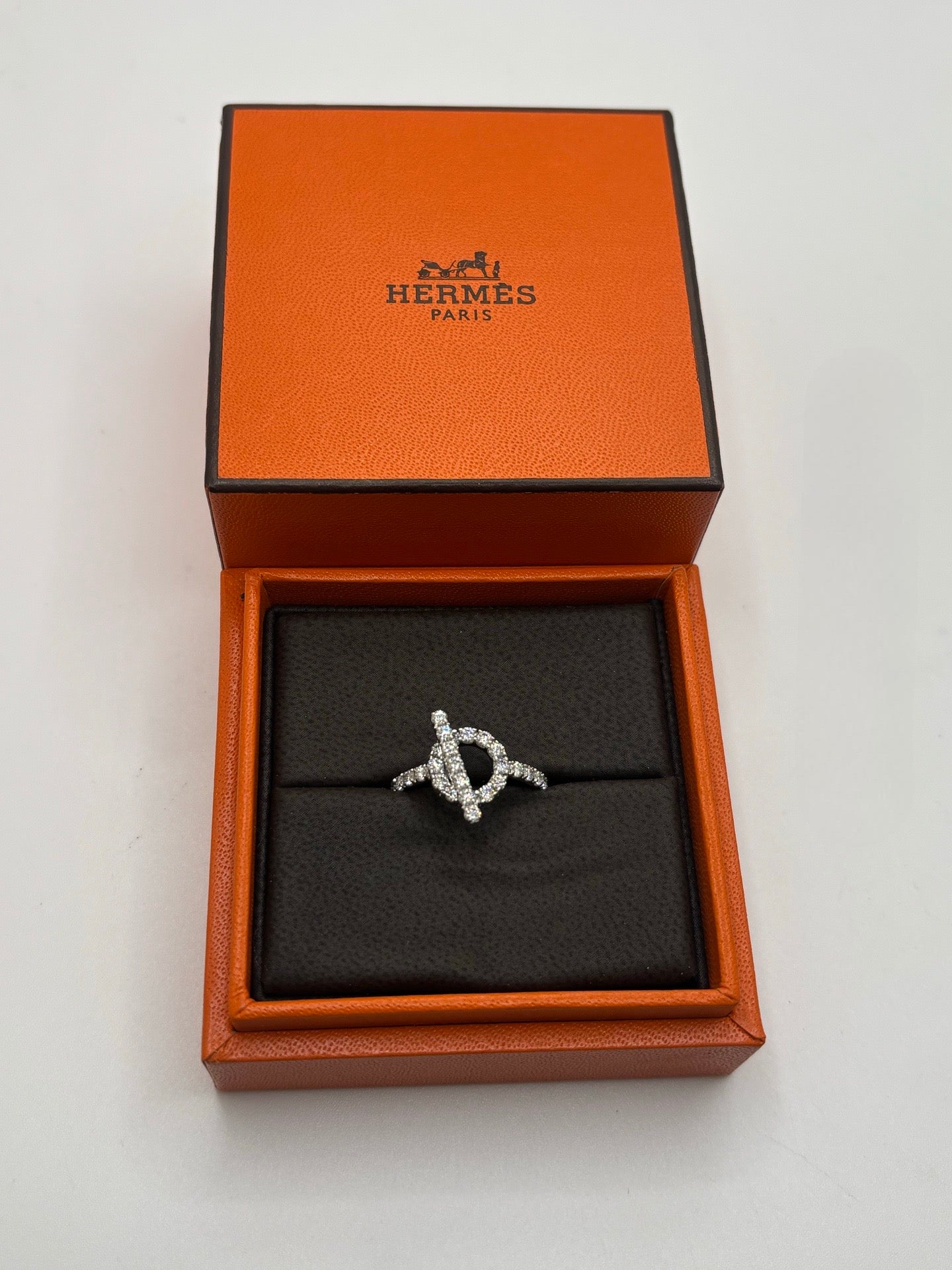 Bague Hermès Finesse en or blanc 18K sertie de diamants totalisant environ 1 carat. Cette création joaillière raffinée associe la modernité de l’or blanc 750 millièmes à l’éclat intemporel des diamants. Bijou de luxe élégant au design délicat et féminin, idéal pour une occasion spéciale, une collection de haute joaillerie ou un cadeau précieux. Finitions soignées et style sophistiqué emblématique du savoir-faire Hermès.
