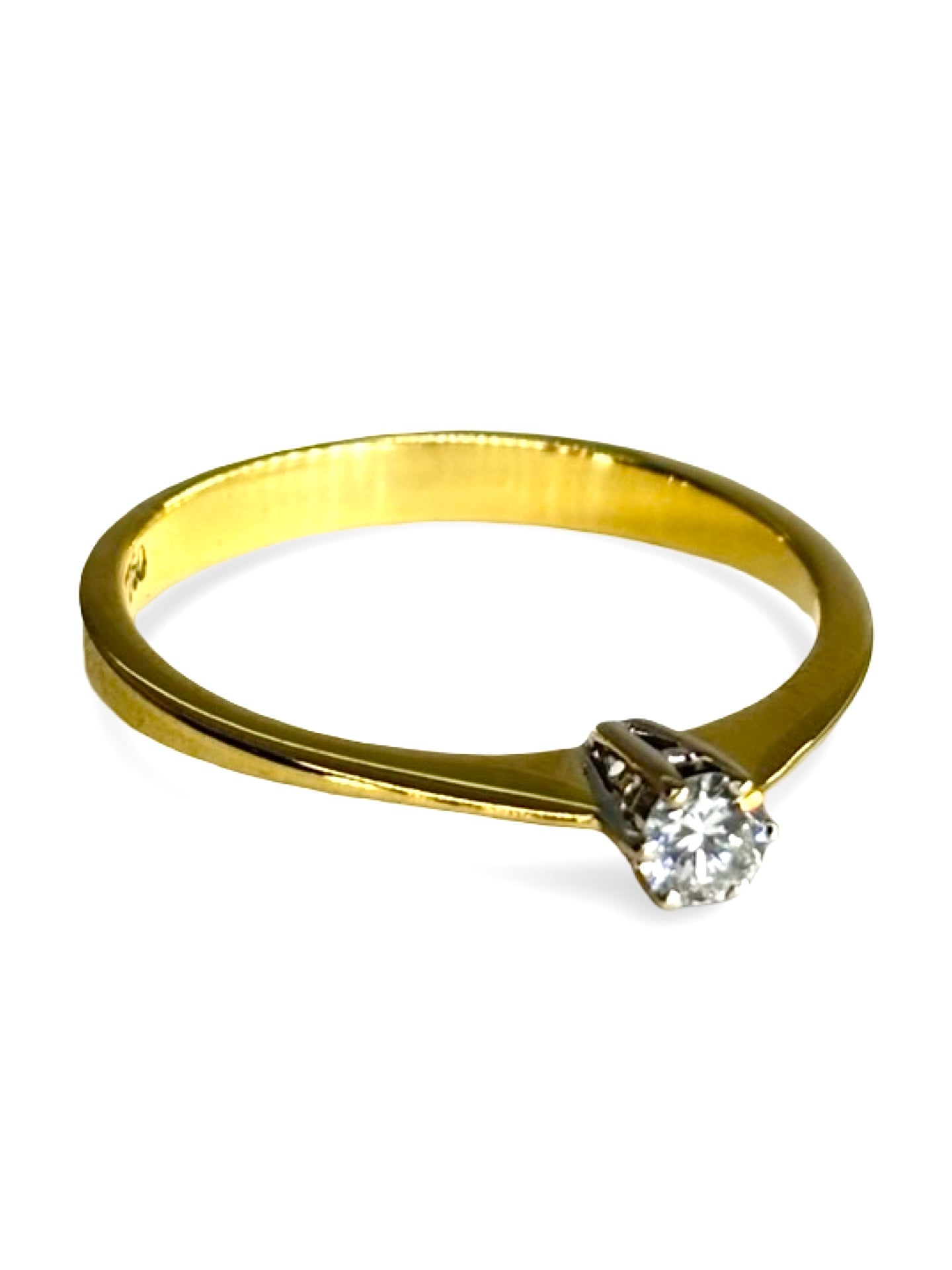 Solitaire en or jaune 18 carats serti d’un diamant taille brillant de 0,13 carat. Son design épuré met en valeur l’éclat naturel de la pierre et la chaleur lumineuse de l’or jaune. Élégante et intemporelle, cette bague incarne la simplicité raffinée et s’adapte aussi bien à une demande en mariage qu’à un bijou symbolique à porter au quotidien.