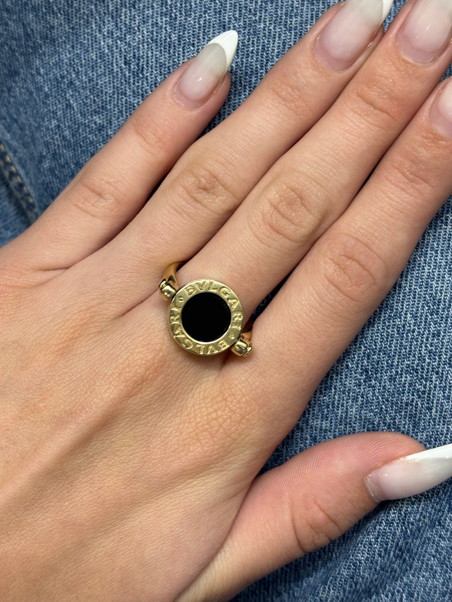Raffinée et originale, cette bague réversible signée Bulgari est façonnée en or jaune 18 carats. Elle révèle deux facettes précieuses : une face en nacre lumineuse et une autre en onyx profond, offrant deux styles en un seul bijou. Symbole du design italien audacieux, cette création incarne l’élégance contemporaine et la versatilité, parfaite pour sublimer toutes vos tenues avec une touche de caractère.