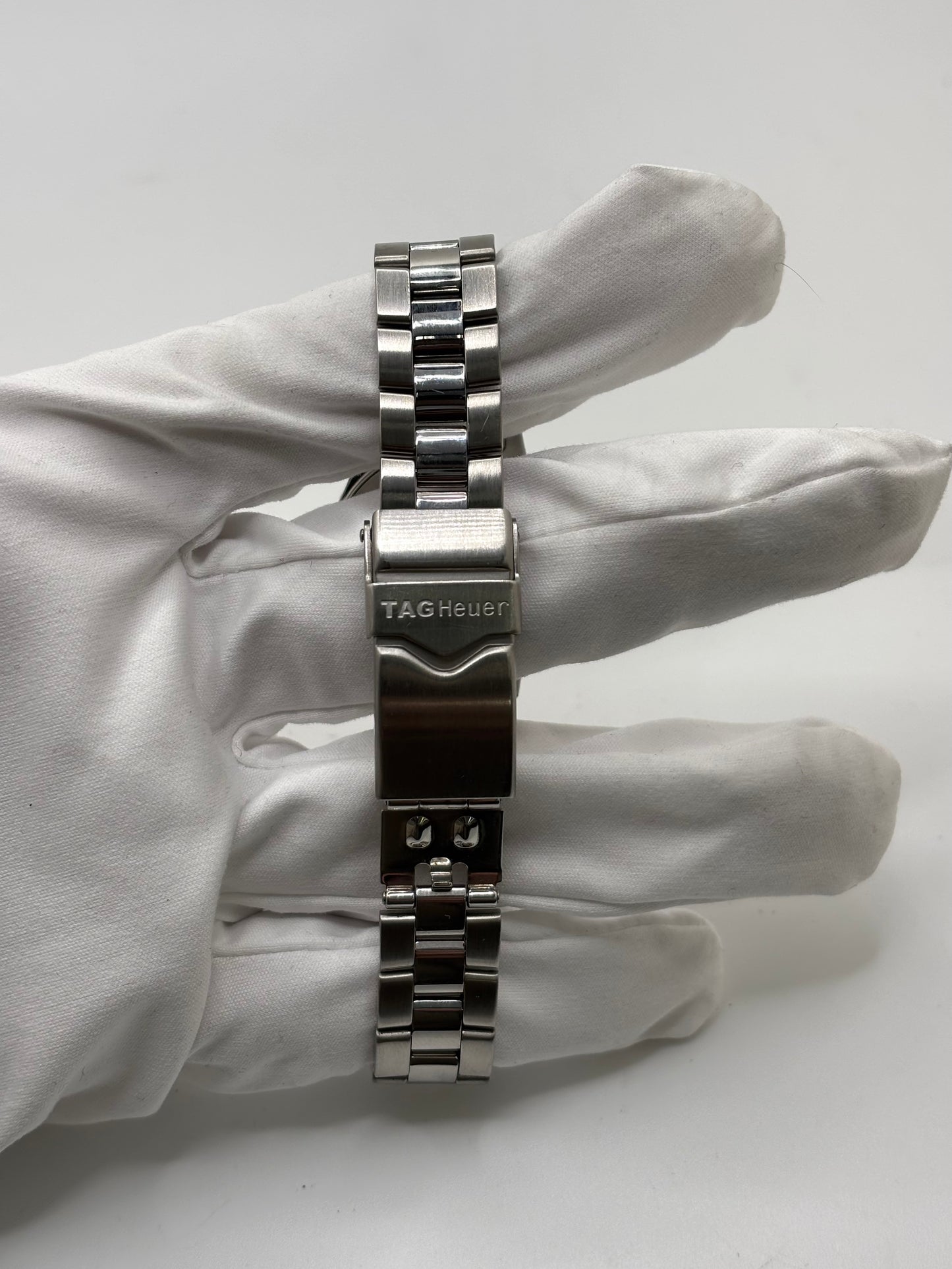 Montre femme TAG Heuer Aquaracer Lady référence WAF1412 en acier avec boîtier 27 mm et bracelet acier. Cadran argent avec chiffres arabes, mouvement quartz précis et étanchéité 30 ATM. Montre de luxe sportive et élégante en très bon état, révisée en 2026, idéale pour un usage quotidien ou une tenue habillée. Détail du boîtier acier poli, montre horlogère suisse féminine, intemporelle et raffinée.