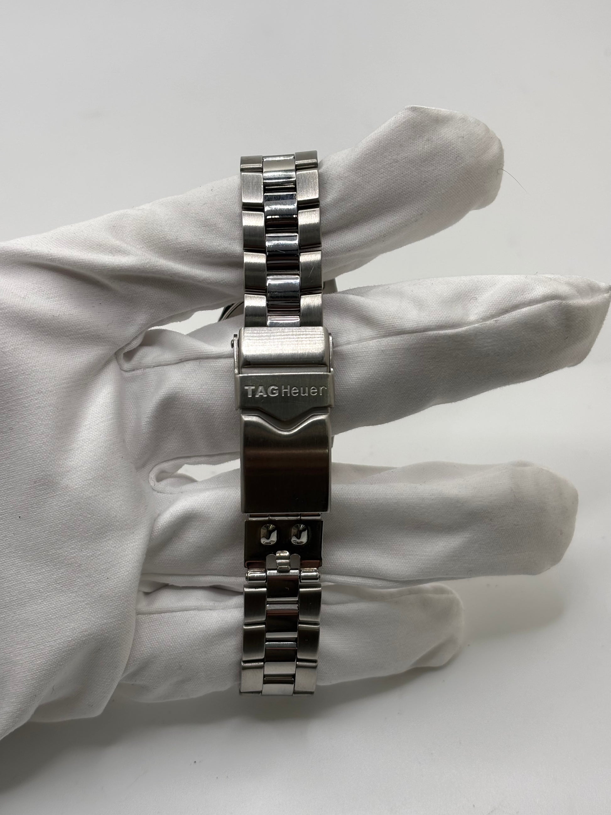 Montre femme TAG Heuer Aquaracer Lady référence WAF1412 en acier avec boîtier 27 mm et bracelet acier. Cadran argent avec chiffres arabes, mouvement quartz précis et étanchéité 30 ATM. Montre de luxe sportive et élégante en très bon état, révisée en 2026, idéale pour un usage quotidien ou une tenue habillée. Détail du boîtier acier poli, montre horlogère suisse féminine, intemporelle et raffinée.