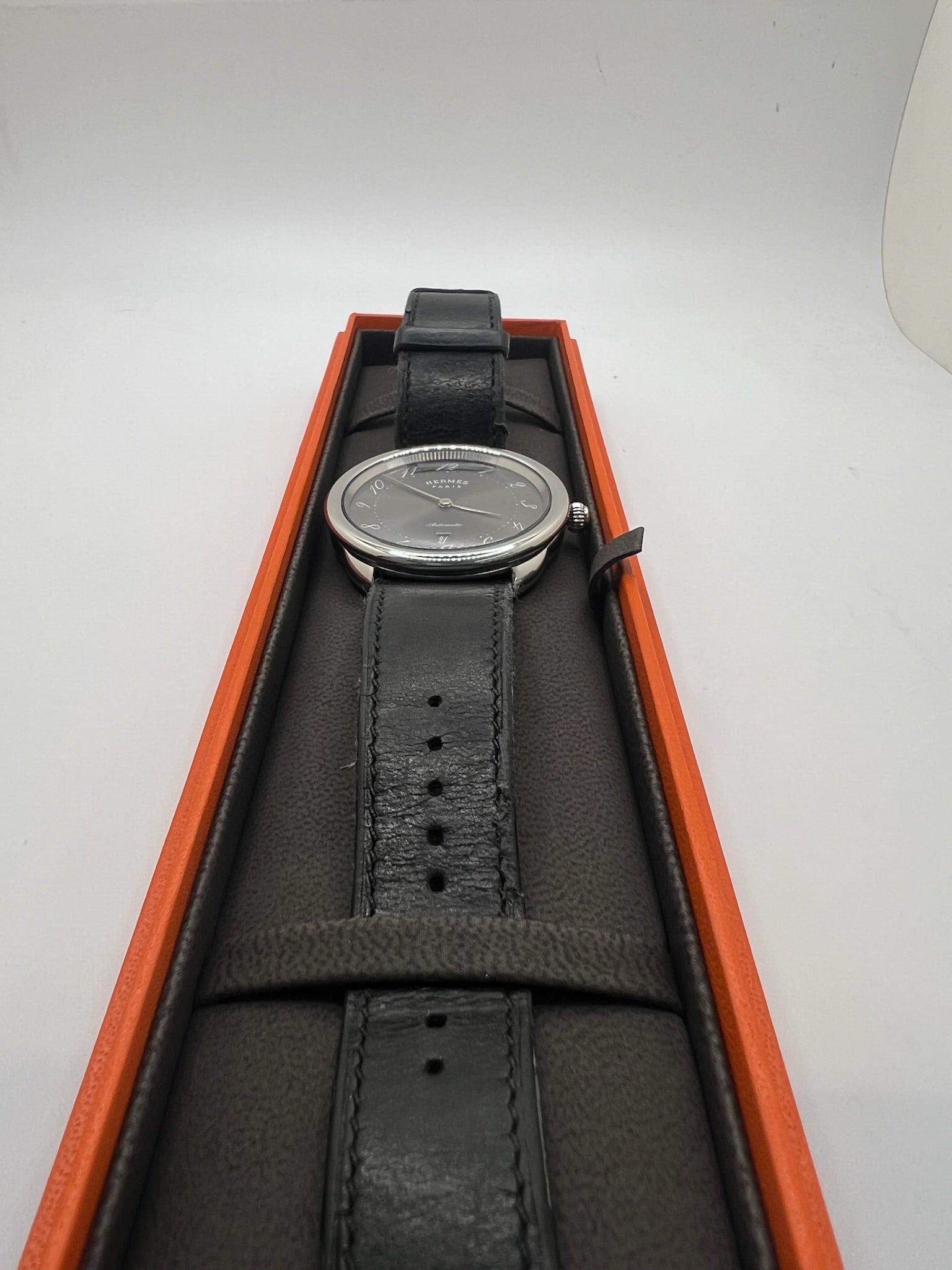 Découvrez la montre Hermès Arceau, un garde-temps d’exception alliant élégance et savoir-faire horloger. Ce modèle emblématique, doté d’un boîtier en acier de 41 mm et d’un mouvement automatique, séduit par son cadran brun raffiné et son bracelet en cuir assorti. Parfaite pour les amateurs de montres de luxe, l’Arceau incarne l’élégance à la française. 