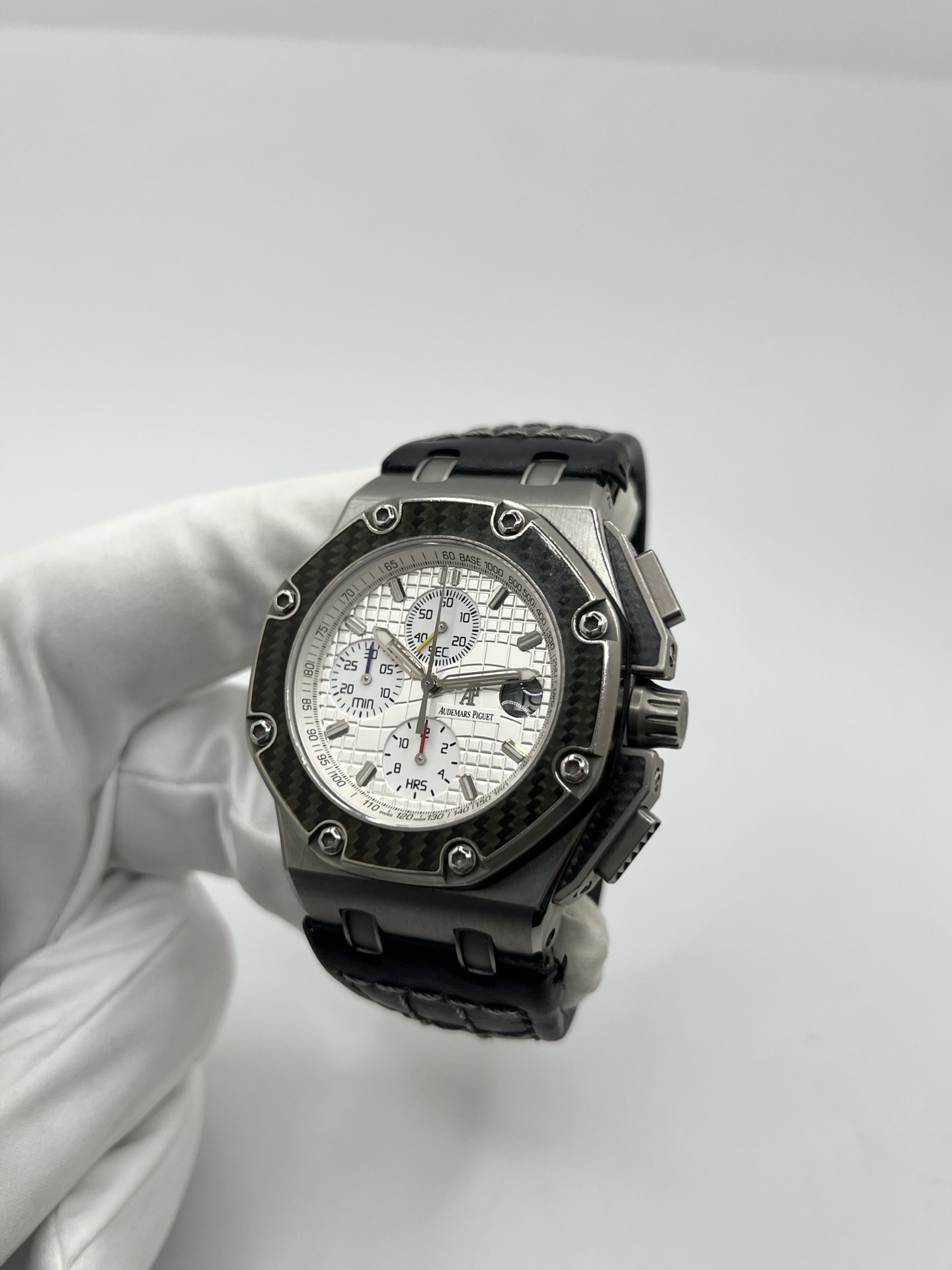 Montre Audemars Piguet Royal Oak Offshore “Juan Pablo Montoya” réf. 26030IO.OO.D001IN.01 en titane avec lunette carbone et cadran argent. Cette édition limitée à 1000 exemplaires est équipée du mouvement automatique Audemars Piguet calibre 2226/2840 avec fonction chronographe et date. Royal Oak Offshore de 44 mm inspirée de la Formule 1, avec fond transparent, bracelet cuir noir et papiers d’origine de 2004. Montre de collection rare et recherchée.