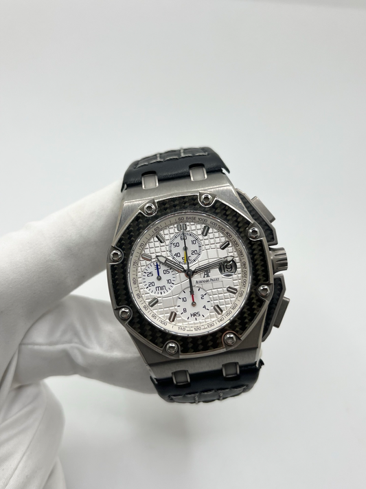 Montre Audemars Piguet Royal Oak Offshore “Juan Pablo Montoya” réf. 26030IO.OO.D001IN.01 en titane avec lunette carbone et cadran argent. Cette édition limitée à 1000 exemplaires est équipée du mouvement automatique Audemars Piguet calibre 2226/2840 avec fonction chronographe et date. Royal Oak Offshore de 44 mm inspirée de la Formule 1, avec fond transparent, bracelet cuir noir et papiers d’origine de 2004. Montre de collection rare et recherchée.