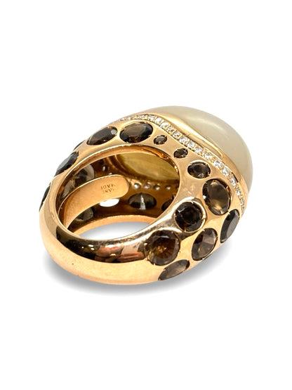 Bague Anjara en or jaune 18 carats mettant en valeur l’association harmonieuse d’une pierre de lune, d’un quartz fumé et de diamants étincelants. Ce bijou raffiné séduit par le contraste de ses gemmes, la douceur de ses reflets et son élégance intemporelle. Une création joaillière idéale pour les amateurs de pierres fines et de bijoux de caractère.