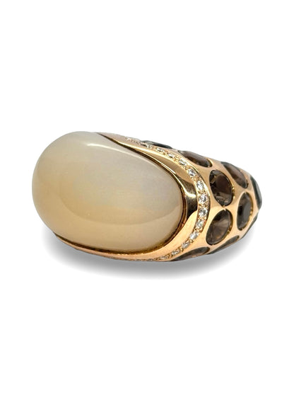 Bague Anjara en or jaune 18 carats mettant en valeur l’association harmonieuse d’une pierre de lune, d’un quartz fumé et de diamants étincelants. Ce bijou raffiné séduit par le contraste de ses gemmes, la douceur de ses reflets et son élégance intemporelle. Une création joaillière idéale pour les amateurs de pierres fines et de bijoux de caractère.