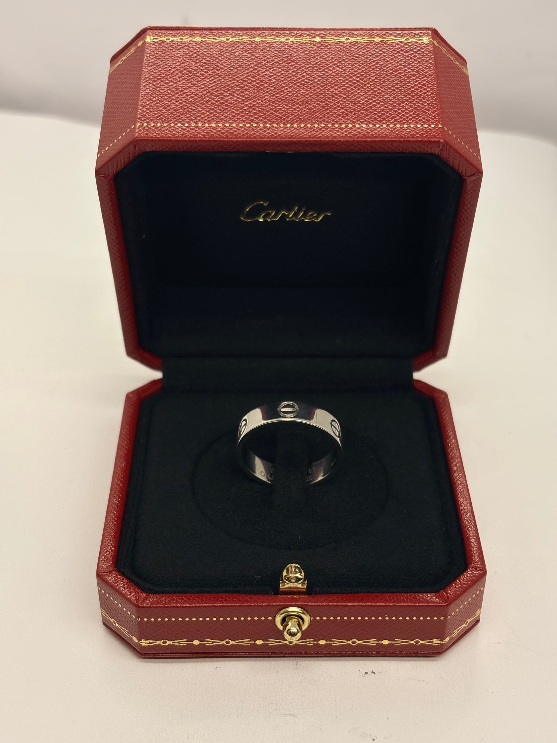 Bague Cartier Love modèle classique en or blanc 18K (750 millièmes). Cette bague iconique de la maison Cartier se distingue par son design intemporel et ses lignes épurées. Comme neuve, elle est accompagnée de son écrin d’origine ainsi que de sa facture d’achat. Avec un poids de 6,8 g et un tour de doigt de 61, cette bague en or blanc Cartier Love constitue un bijou élégant et raffiné, idéal pour les amateurs de joaillerie de luxe.
