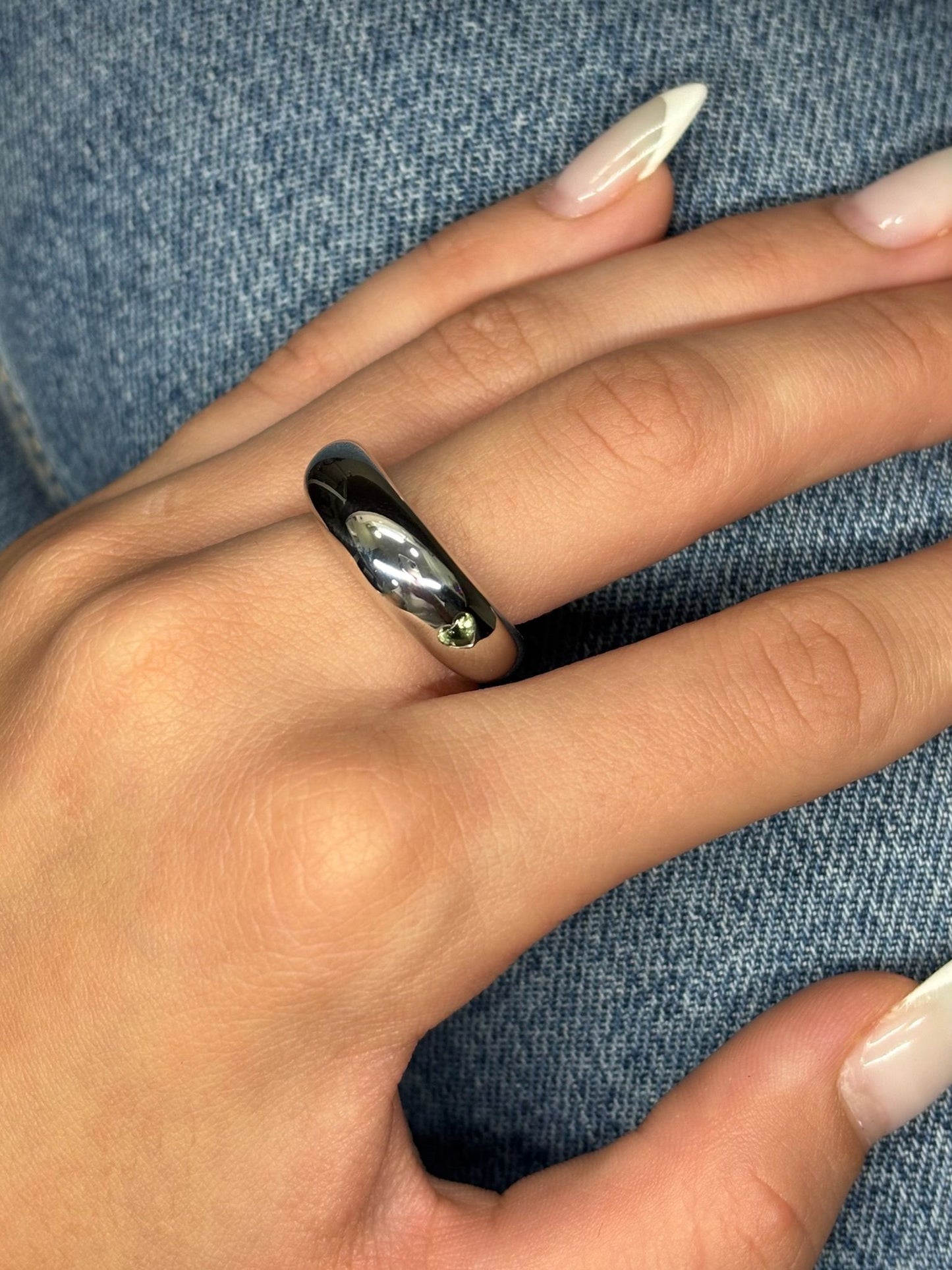 Bague jonc signée Chaumet, en or blanc 18 carats, sublimée par un saphir vert au ton raffiné. Cette création épurée incarne l’élégance contemporaine de la maison, alliant pureté des lignes et éclat précieux de la pierre. Son design minimaliste met en valeur la rareté du saphir vert, pour un bijou à la fois discret et sophistiqué, parfait pour accompagner avec distinction les moments du quotidien comme les grandes occasions.