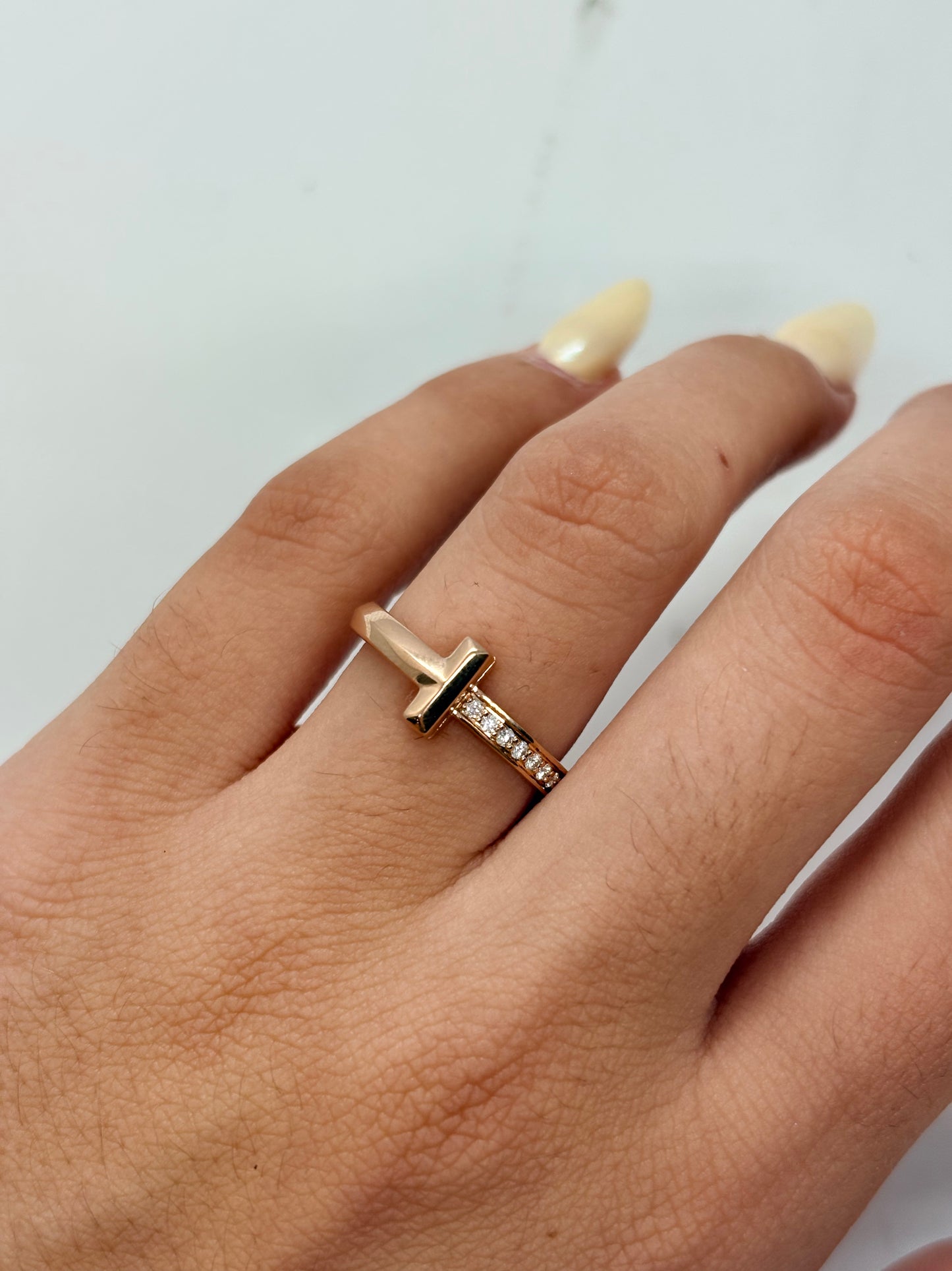 Bague Tiffany & Co modèle Tiffany T en or rose 18K, élégante et contemporaine, ornée de diamants d’un poids total de 0,08 ct. Cette bague de joaillerie signée Tiffany & Co séduit par son design emblématique Tiffany T, ses lignes raffinées et son éclat délicat. Un bijou en or rose 18 carats idéal pour une allure chic et moderne, à porter au quotidien ou pour une occasion spéciale. Bague de luxe, bijou Tiffany & Co et pièce intemporelle.