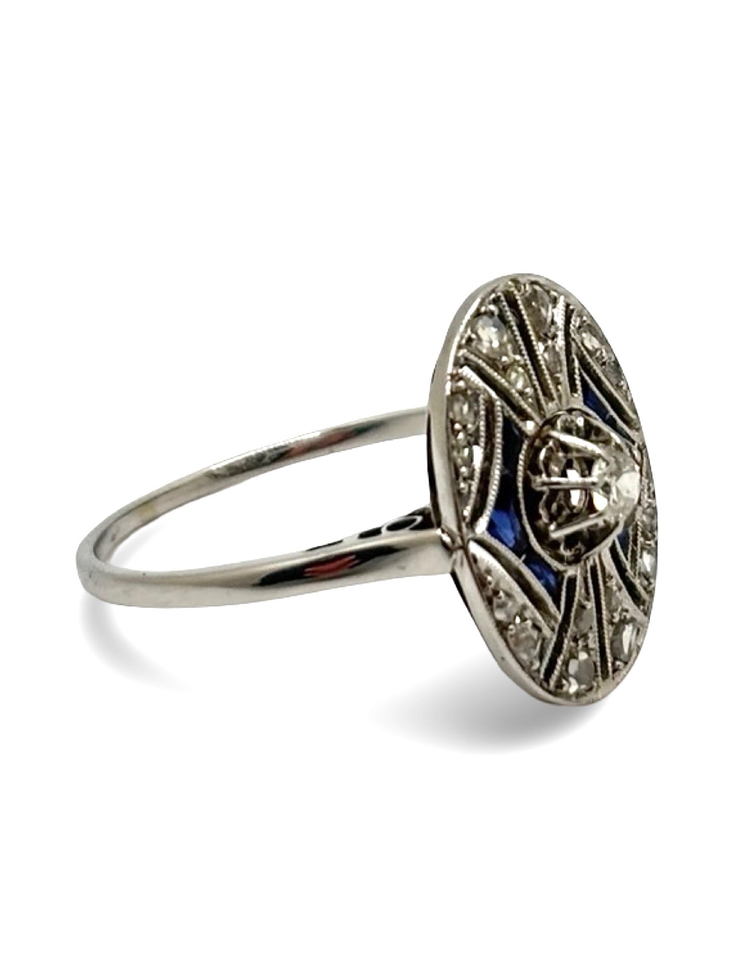 Bague ancienne en or blanc sertie de saphirs bleus et de diamants totalisant 0,25 carat. Bijou vintage au charme intemporel, inspiré des styles anciens, mettant en valeur le contraste entre l’éclat des diamants et la profondeur des saphirs. Idéale pour collection, cadeau ou bague de caractère, elle incarne l’élégance, le raffinement et l’authenticité de la joaillerie ancienne.