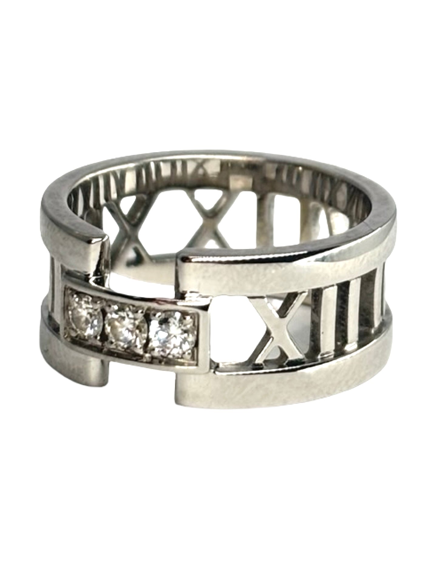 Bague Atlas ring en or blanc signée Tiffany & Co., sertie de diamants totalisant 0,15 carat. Son design graphique emblématique, inspiré des chiffres romains, allie modernité et élégance intemporelle. Un bijou raffiné et lumineux, idéal pour sublimer la main au quotidien ou marquer une occasion spéciale avec une pièce iconique de la joaillerie de luxe.