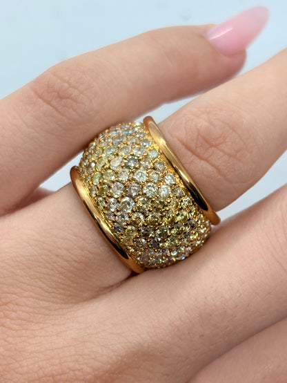 Bague dôme en or jaune 18K sublimée par un ensemble de diamants naturels pour un poids total d’environ 7 carats. Son design bombé et généreux met en valeur l’éclat des diamants et la chaleur de l’or jaune 18 carats. Cette bague de joaillerie offre une présence remarquable au doigt tout en conservant une allure élégante et raffinée. Une pièce précieuse et lumineuse, idéale pour les amateurs de bijoux d’exception.