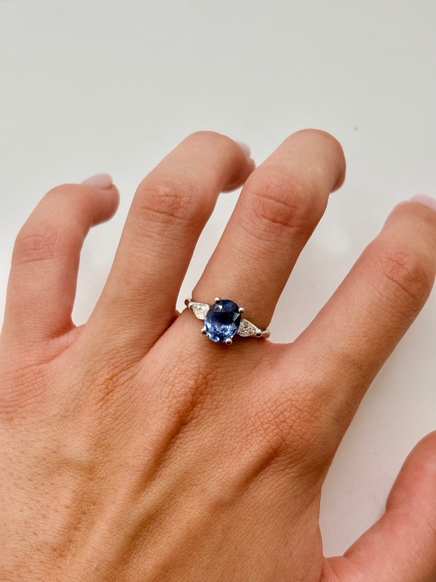 Bague en or blanc 18K sublimée par un magnifique saphir de Ceylan de 2,1 carats, entouré de diamants totalisant 0,38 carat. Cette bague d'exception allie l'éclat intemporel de l'or blanc à la profondeur du saphir naturel et à la brillance des diamants. Idéale comme bague de fiançailles, cadeau précieux ou bijou de luxe, elle séduit par son élégance raffinée et son style intemporel.