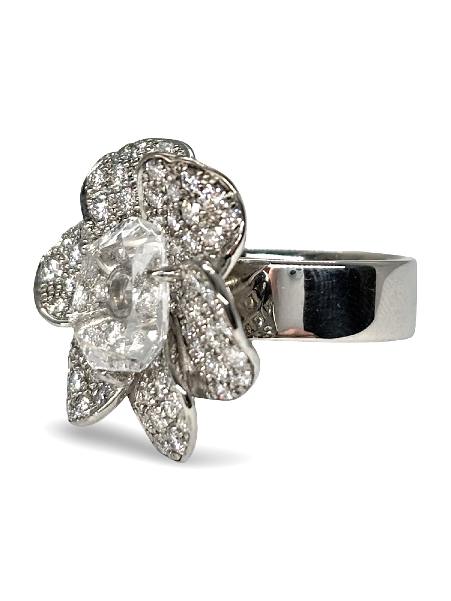 Bague motif fleur en or blanc 18 carats ornée de diamants totalisant 1 carat et de cristal. Ce bijou raffiné séduit par son design floral délicat, la brillance des diamants et la transparence lumineuse du cristal. Une bague élégante et précieuse, idéale pour sublimer une tenue ou enrichir une collection de joaillerie.