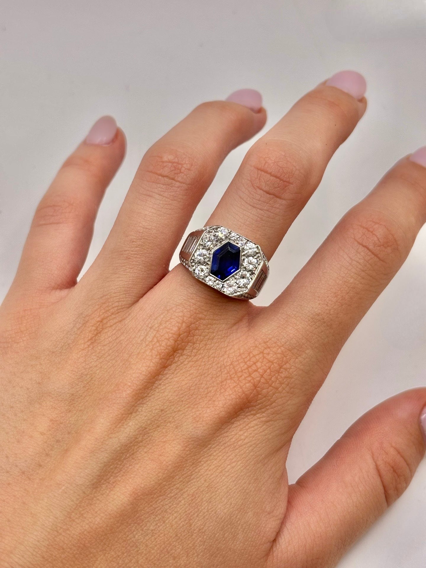 Bague en or blanc 18 carats mettant en valeur un somptueux saphir de 1,5 carat entouré de diamants totalisant 1,88 carat. Ce bijou d’exception séduit par l’intensité du bleu du saphir et l’éclat des diamants. Une création élégante et intemporelle, idéale pour les amateurs de haute joaillerie et de pierres précieuses.