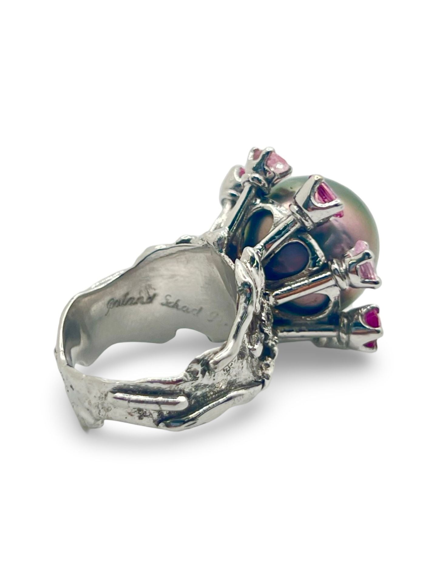 Découvrez cette élégante bague en or blanc signée Roland Schad, un bijou unique mettant en valeur une perle de Tahiti d'exception et des saphirs roses naturels. Ce design raffiné allie parfaitement la douceur de la perle de Tahiti à la brillance des pierres précieuses, offrant ainsi une pièce intemporelle pour les amateurs de joaillerie fine. Idéale pour ceux qui recherchent une bague sophistiquée et originale.