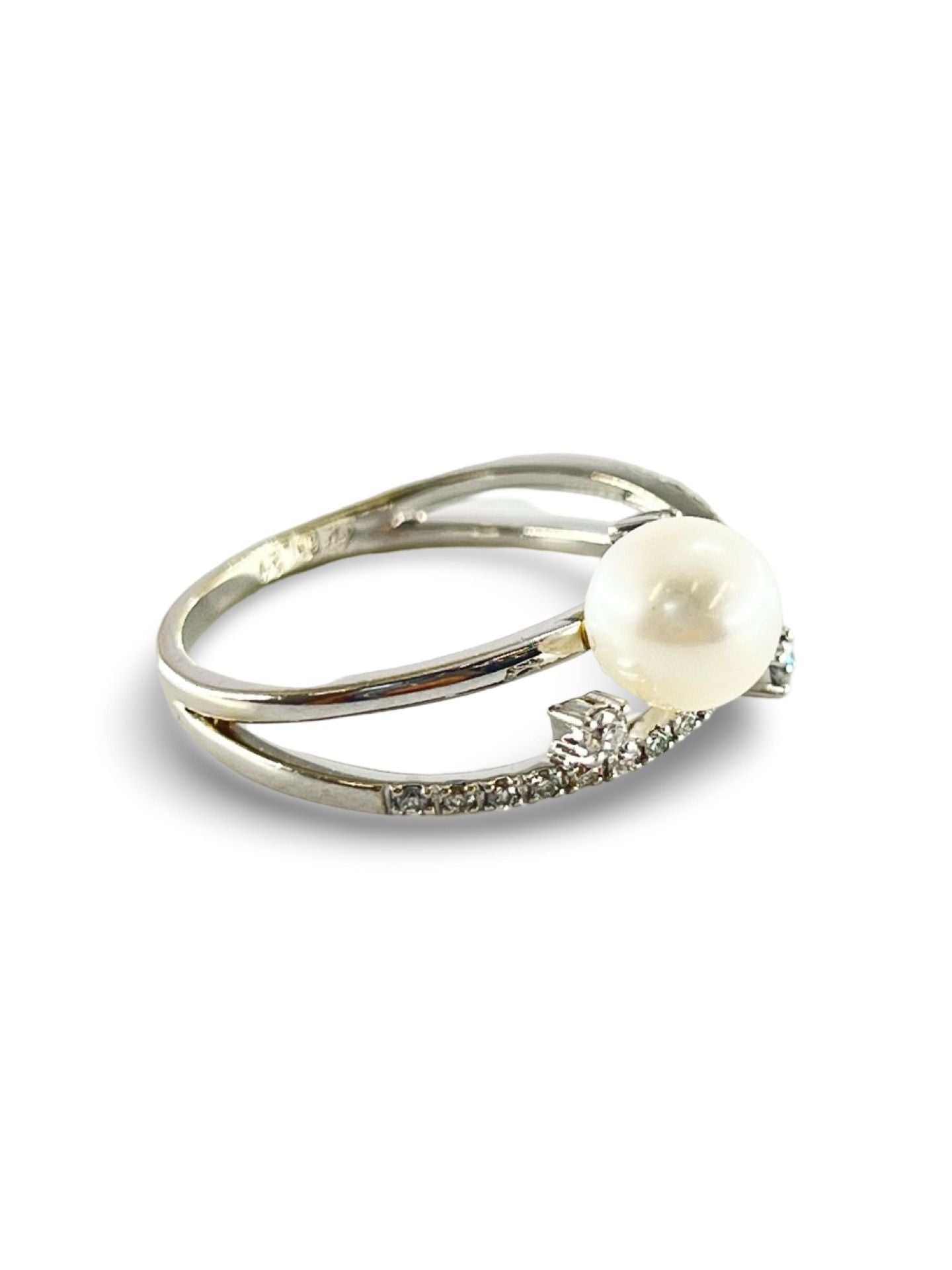 Découvrez une magnifique bague en or blanc, sertie d'une perle de 6,9 mm, accompagnée de trois diamants naturels de 0,025 ct et de vingt et un petits diamants de 0,0067 ct. Idéale pour sublimer vos occasions spéciales, cette pièce raffinée allie élégance et éclat, offrant un contraste parfait entre la douceur de la perle et le scintillement des diamants.