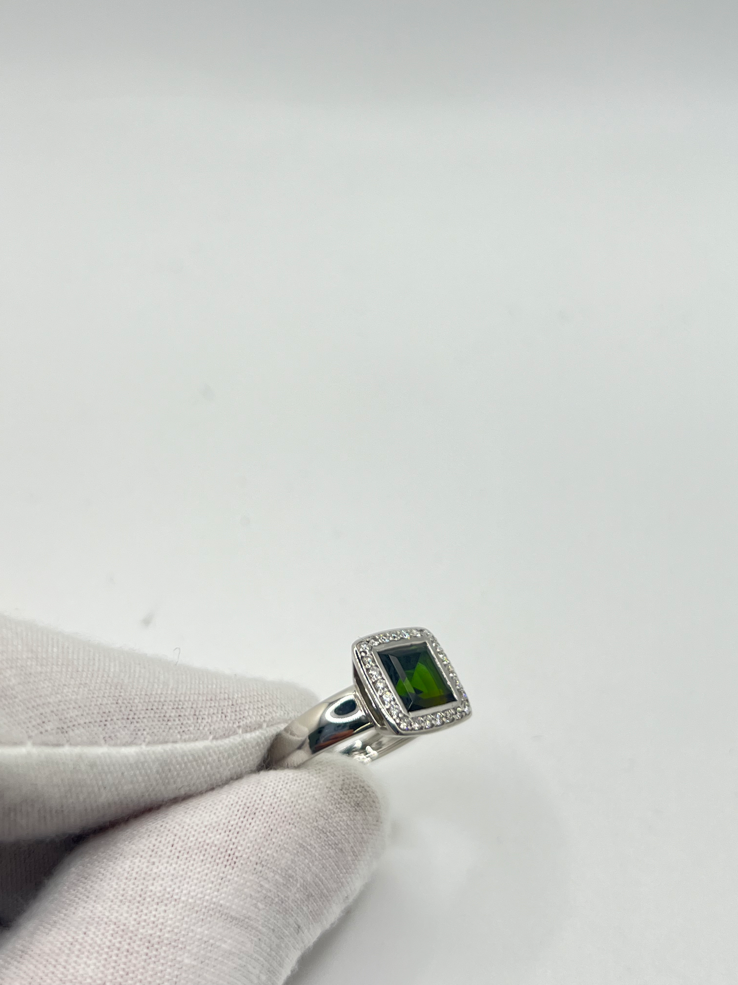Découvrez cette élégante bague en or blanc, sertie d'une tourmaline verte de 2 carats environ, accompagnée de diamants scintillants. Ce bijou raffiné est présenté dans un écrin élégant, parfait pour offrir un cadeau précieux. Idéale pour toutes les occasions spéciales, cette bague combine la beauté de l'or blanc et l'éclat unique de la tourmaline verte, sublimée par la brillance des diamants.