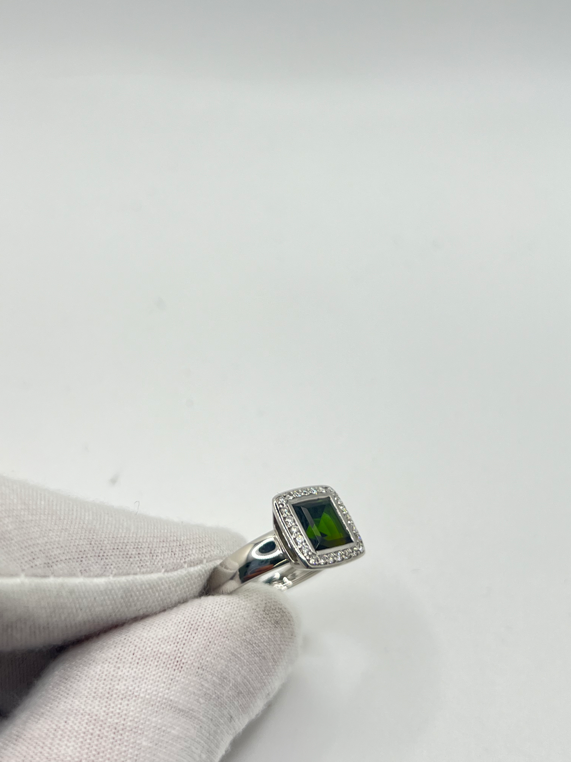 Découvrez cette élégante bague en or blanc, sertie d'une tourmaline verte de 2 carats environ, accompagnée de diamants scintillants. Ce bijou raffiné est présenté dans un écrin élégant, parfait pour offrir un cadeau précieux. Idéale pour toutes les occasions spéciales, cette bague combine la beauté de l'or blanc et l'éclat unique de la tourmaline verte, sublimée par la brillance des diamants.