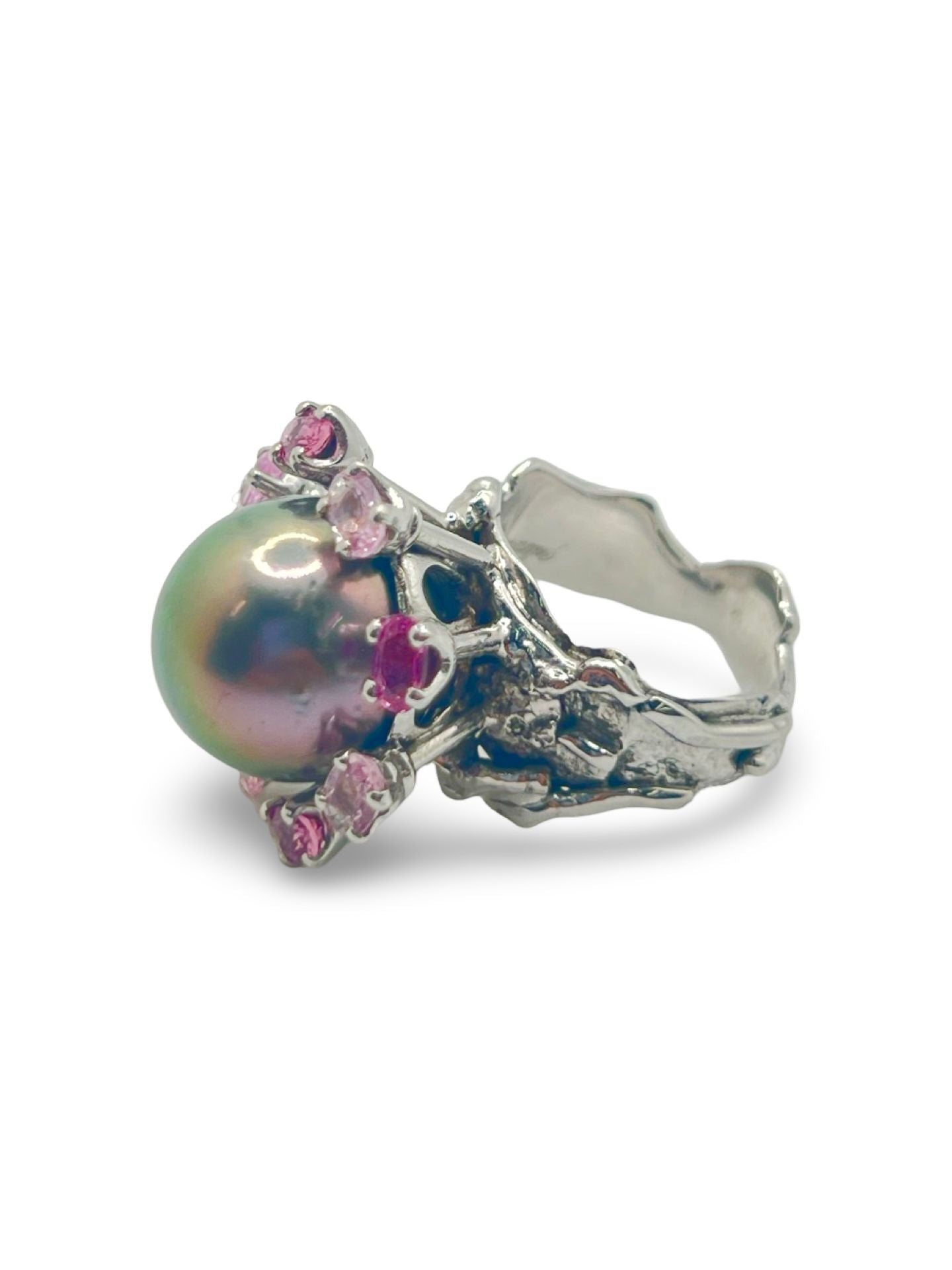 Découvrez cette élégante bague en or blanc signée Roland Schad, un bijou unique mettant en valeur une perle de Tahiti d'exception et des saphirs roses naturels. Ce design raffiné allie parfaitement la douceur de la perle de Tahiti à la brillance des pierres précieuses, offrant ainsi une pièce intemporelle pour les amateurs de joaillerie fine. Idéale pour ceux qui recherchent une bague sophistiquée et originale.