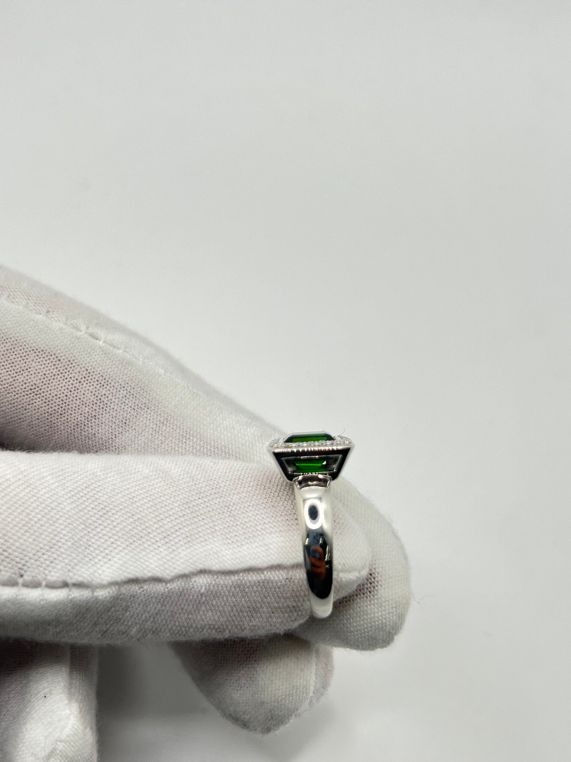 Découvrez cette élégante bague en or blanc, sertie d'une tourmaline verte de 2 carats environ, accompagnée de diamants scintillants. Ce bijou raffiné est présenté dans un écrin élégant, parfait pour offrir un cadeau précieux. Idéale pour toutes les occasions spéciales, cette bague combine la beauté de l'or blanc et l'éclat unique de la tourmaline verte, sublimée par la brillance des diamants.