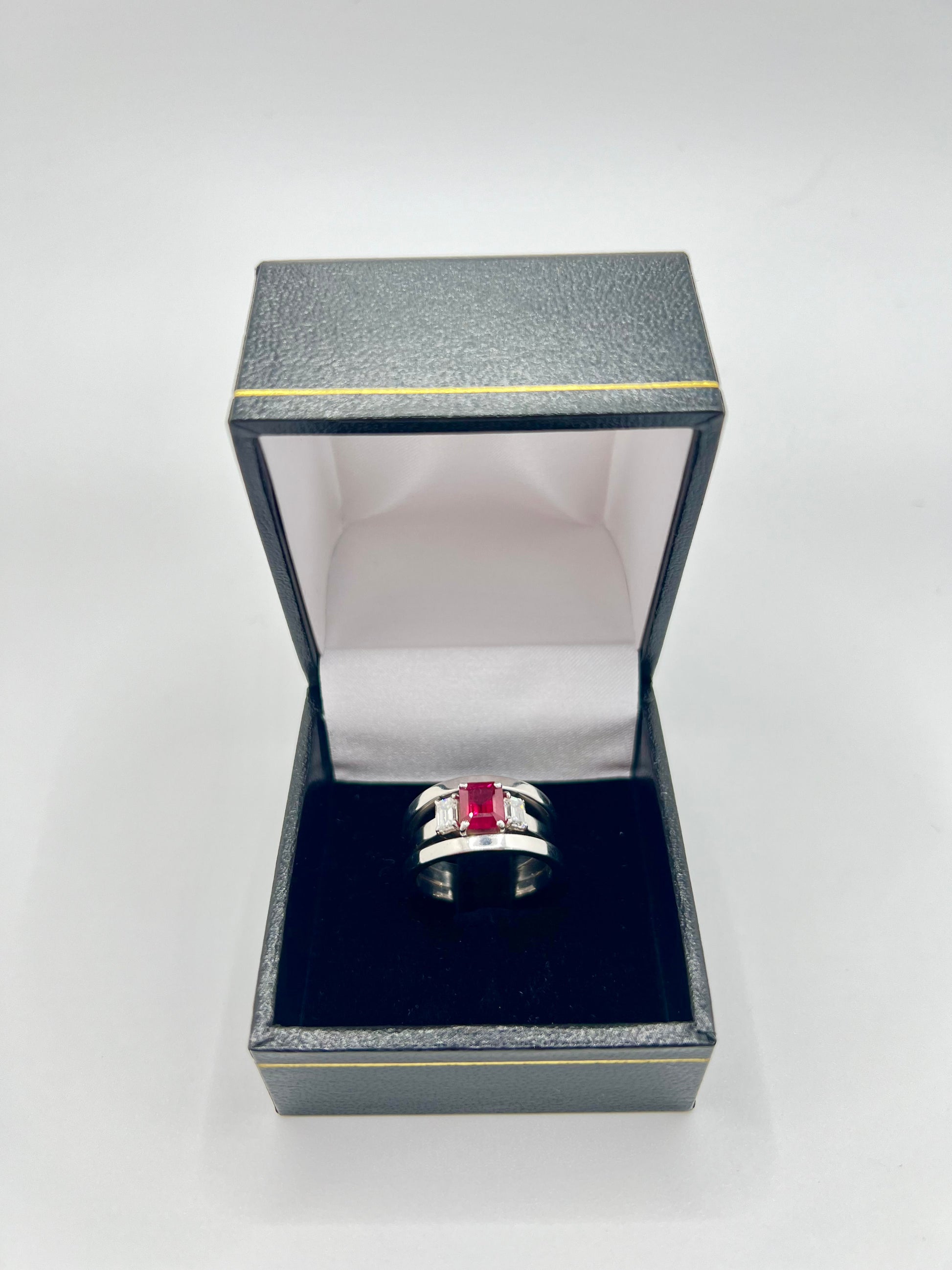 Découvrez cette magnifique bague en or blanc, sublimée par un rubis de 1,40 ct et des diamants taillés en émeraude. Un bijou d'exception, livré dans un écrin raffiné. Cette bague, alliant l'élégance du rubis et la brillance des diamants, sera un cadeau idéal pour une occasion spéciale.