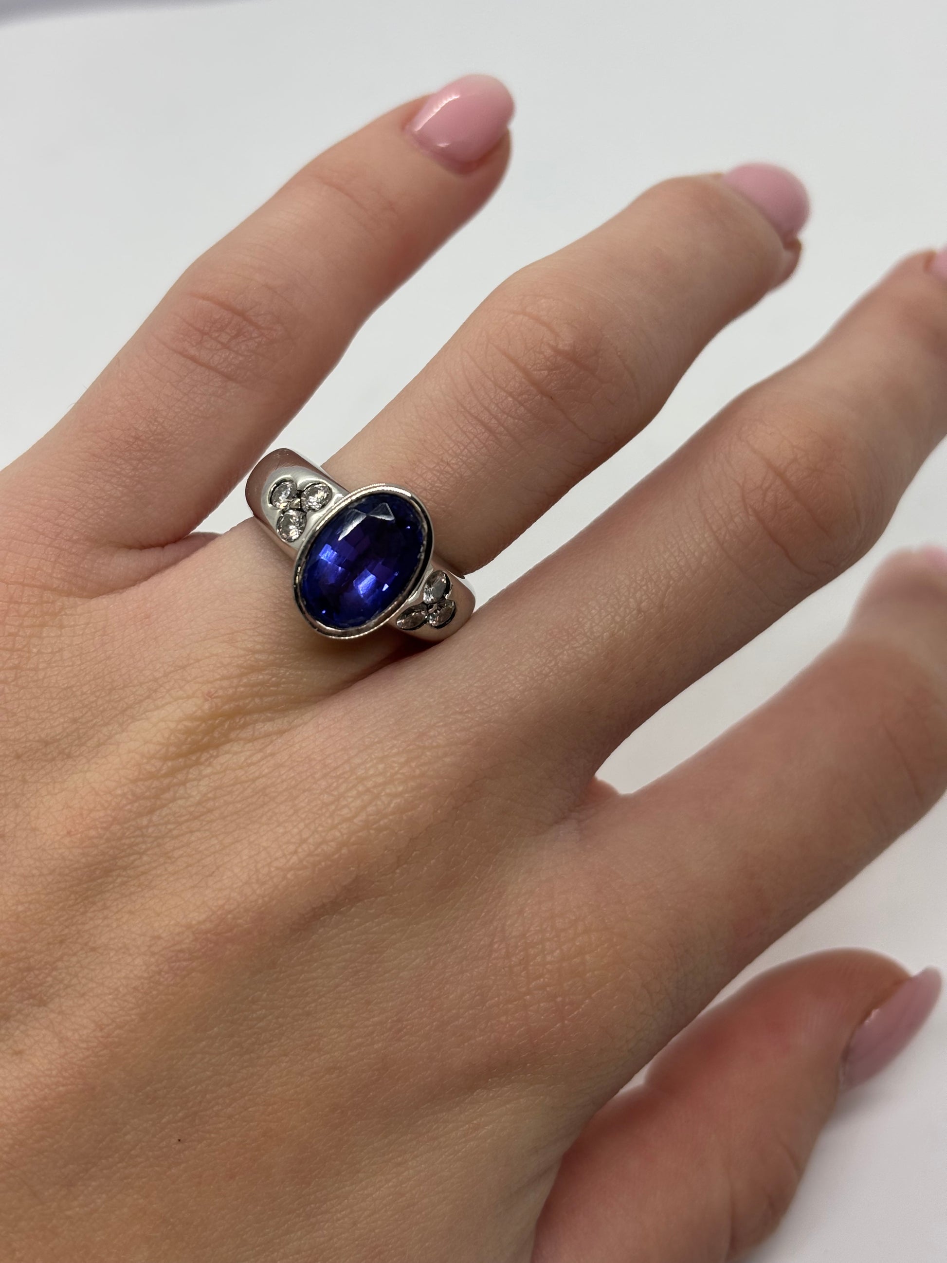 Bague en or blanc sertie d’une tanzanite de 5 carats, accompagnée de 0,6 carat de diamants étincelants. Ce bijou élégant met en valeur la profondeur bleutée de la tanzanite et l’éclat des diamants, offrant une pièce raffinée et intemporelle qui illumine la main avec charme et sophistication.