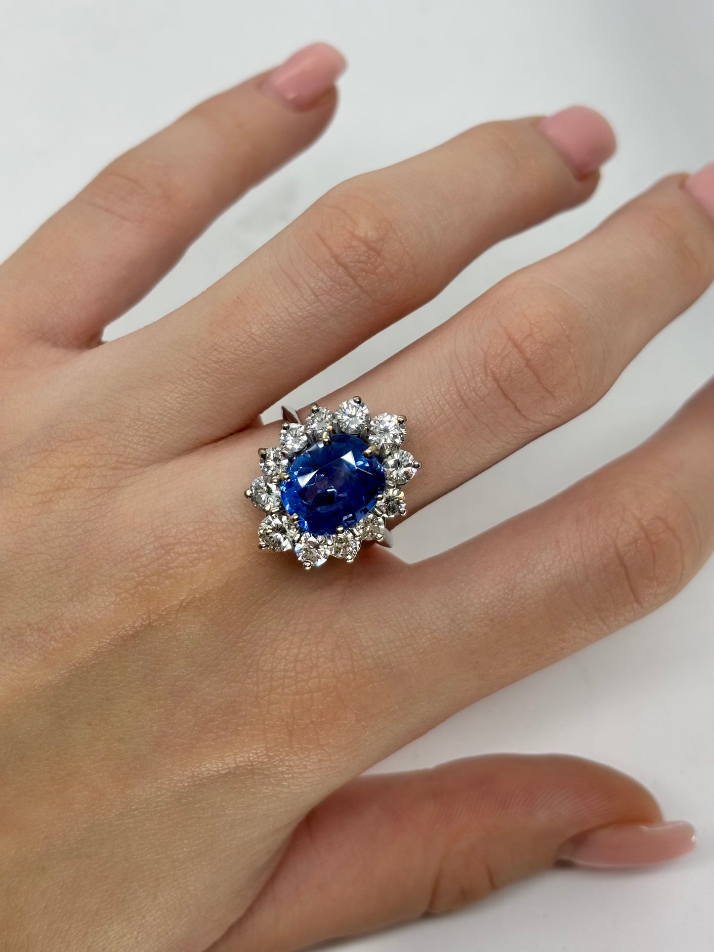 Bague marguerite en or blanc 18K sertie d’un saphir birman non chauffé de 5,58 carats, certifié par le GRS (janvier 2026). Sa couleur bleu profond, intense et veloutée illustre la rareté des saphirs naturels de Birmanie. Il est sublimé par un entourage de diamants naturels totalisant environ 2 carats. Une pièce exceptionnelle, alliant élégance intemporelle, caractère et valeur patrimoniale.