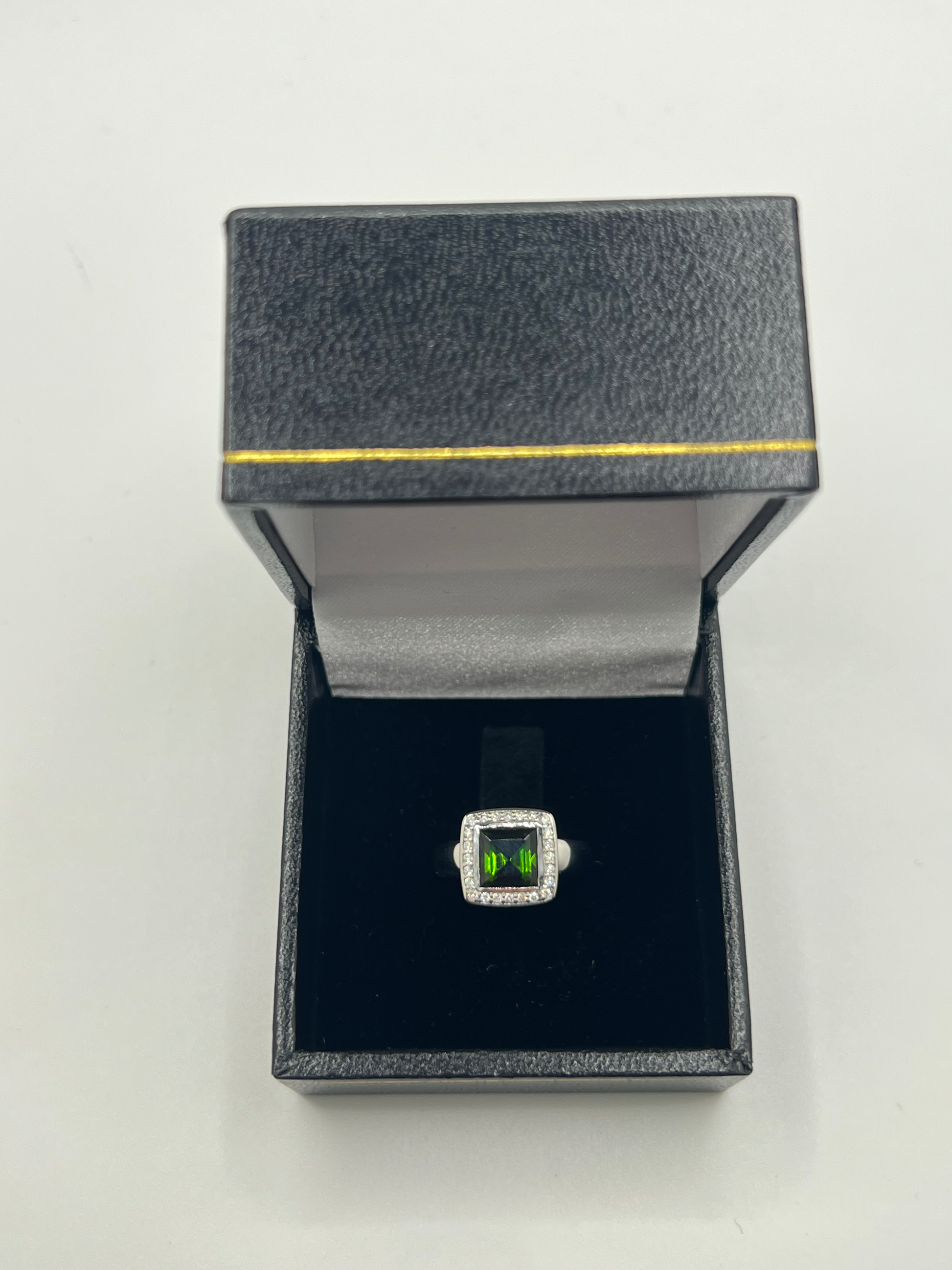 Découvrez cette élégante bague en or blanc, sertie d'une tourmaline verte de 2 carats environ, accompagnée de diamants scintillants. Ce bijou raffiné est présenté dans un écrin élégant, parfait pour offrir un cadeau précieux. Idéale pour toutes les occasions spéciales, cette bague combine la beauté de l'or blanc et l'éclat unique de la tourmaline verte, sublimée par la brillance des diamants.