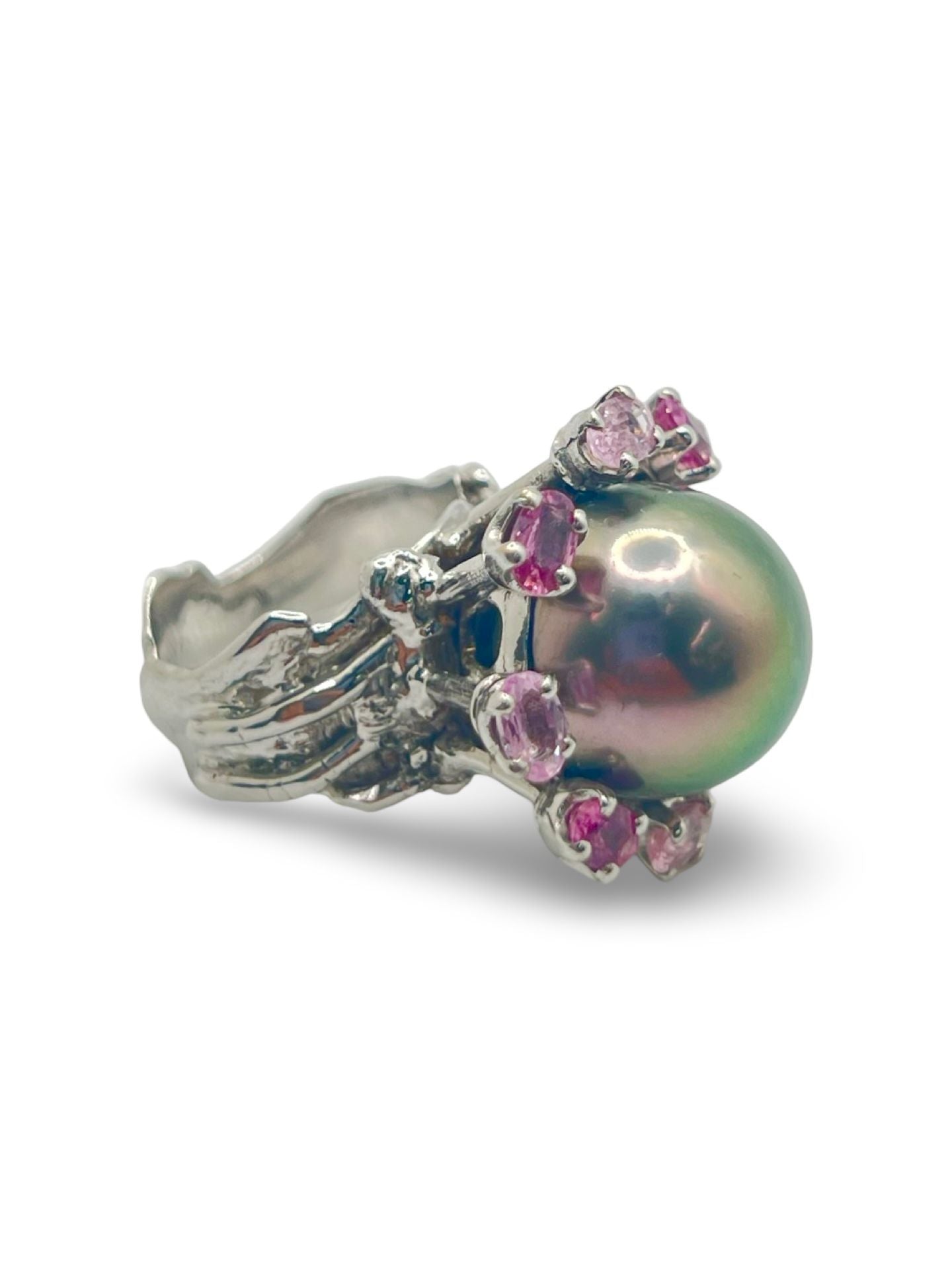 Découvrez cette élégante bague en or blanc signée Roland Schad, un bijou unique mettant en valeur une perle de Tahiti d'exception et des saphirs roses naturels. Ce design raffiné allie parfaitement la douceur de la perle de Tahiti à la brillance des pierres précieuses, offrant ainsi une pièce intemporelle pour les amateurs de joaillerie fine. Idéale pour ceux qui recherchent une bague sophistiquée et originale.