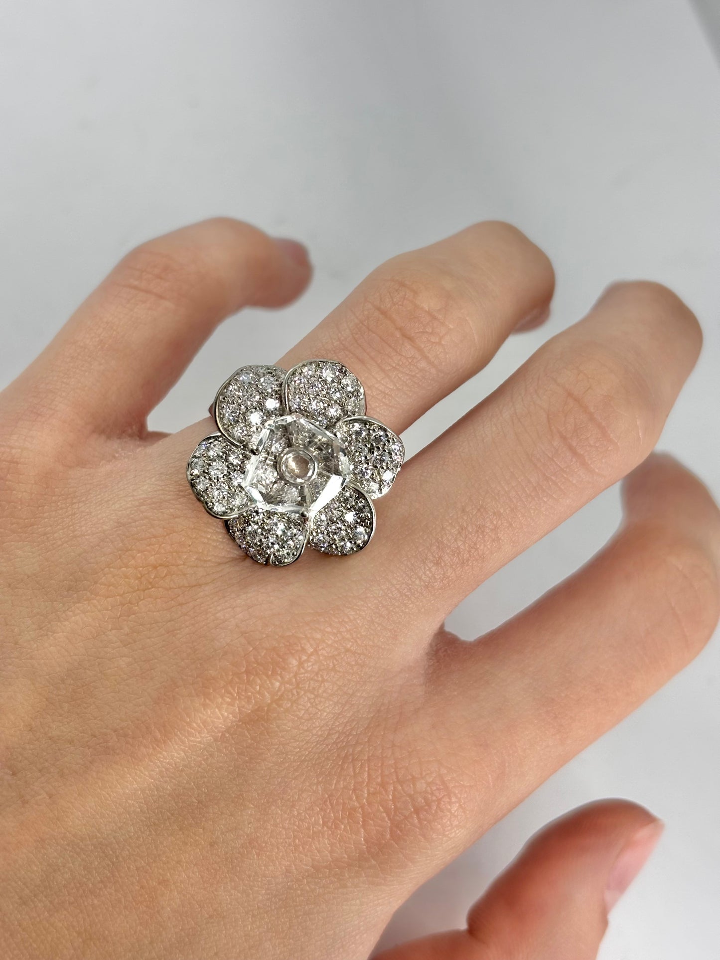Bague motif fleur en or blanc 18 carats ornée de diamants totalisant 1 carat et de cristal. Ce bijou raffiné séduit par son design floral délicat, la brillance des diamants et la transparence lumineuse du cristal. Une bague élégante et précieuse, idéale pour sublimer une tenue ou enrichir une collection de joaillerie.