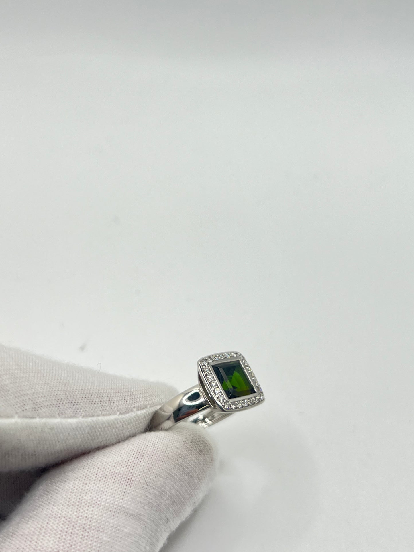 Découvrez cette élégante bague en or blanc, sertie d'une tourmaline verte de 2 carats environ, accompagnée de diamants scintillants. Ce bijou raffiné est présenté dans un écrin élégant, parfait pour offrir un cadeau précieux. Idéale pour toutes les occasions spéciales, cette bague combine la beauté de l'or blanc et l'éclat unique de la tourmaline verte, sublimée par la brillance des diamants.
