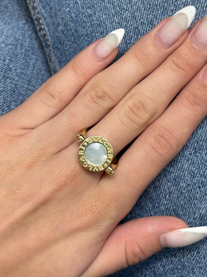 Raffinée et originale, cette bague réversible signée Bulgari est façonnée en or jaune 18 carats. Elle révèle deux facettes précieuses : une face en nacre lumineuse et une autre en onyx profond, offrant deux styles en un seul bijou. Symbole du design italien audacieux, cette création incarne l’élégance contemporaine et la versatilité, parfaite pour sublimer toutes vos tenues avec une touche de caractère.