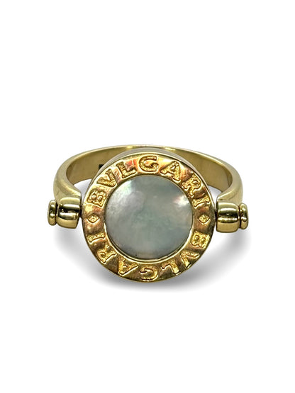 Raffinée et originale, cette bague réversible signée Bulgari est façonnée en or jaune 18 carats. Elle révèle deux facettes précieuses : une face en nacre lumineuse et une autre en onyx profond, offrant deux styles en un seul bijou. Symbole du design italien audacieux, cette création incarne l’élégance contemporaine et la versatilité, parfaite pour sublimer toutes vos tenues avec une touche de caractère.