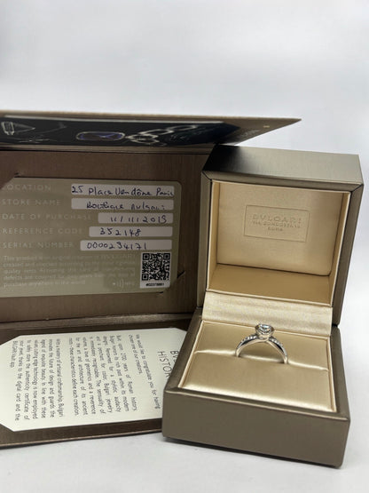 Solitaire Bulgari Incontro D'Amore en platine 950 serti d’un diamant taille brillant de 0,60 carat. Cette bague de fiançailles de luxe reflète l’élégance et le savoir-faire de la maison Bulgari grâce à son design raffiné et intemporel. Le platine met en valeur l’éclat du diamant, faisant de ce solitaire un bijou d’exception idéal pour célébrer un engagement ou enrichir une collection de joaillerie.