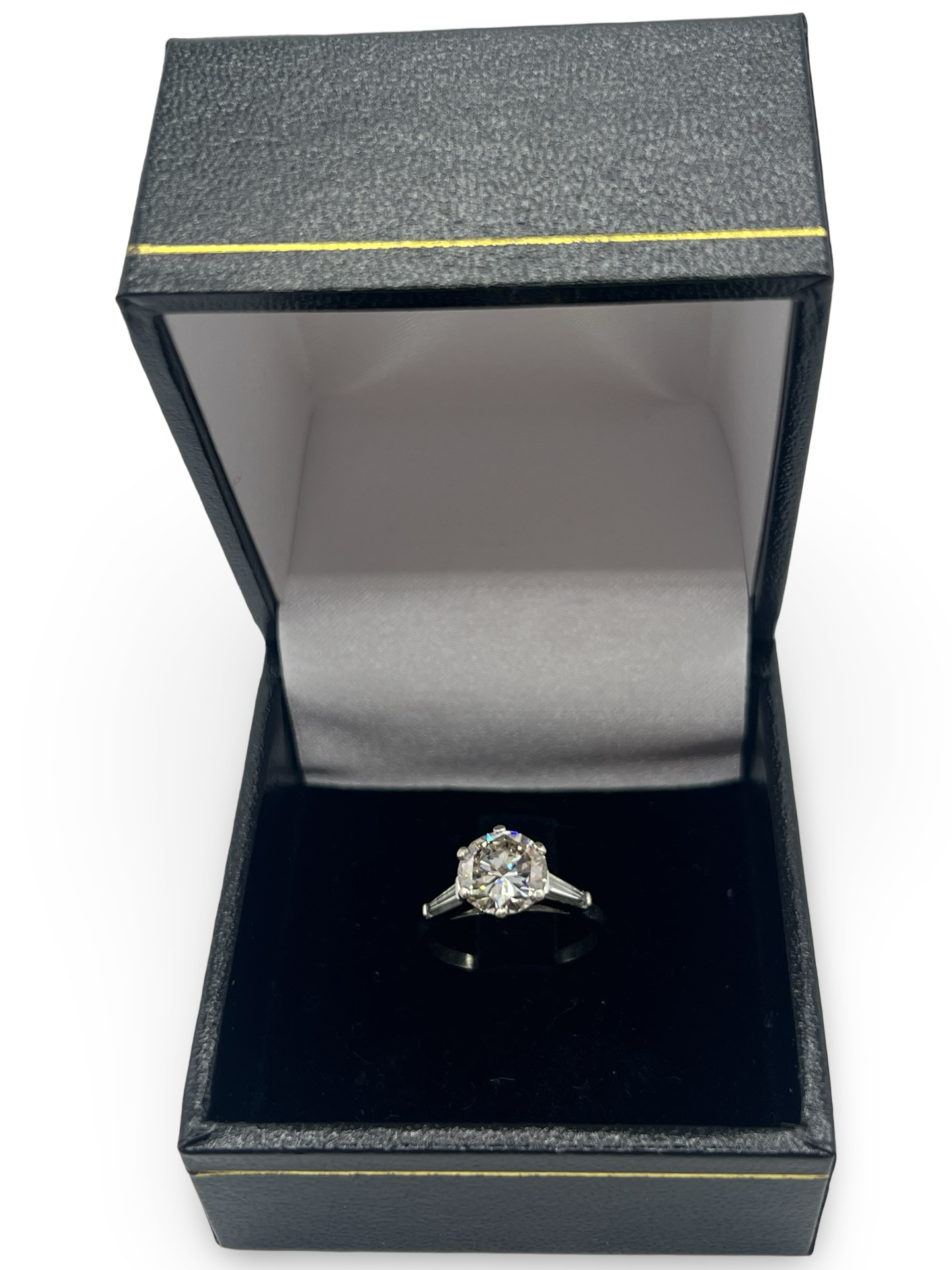 Cette bague solitaire en or blanc est sublimée par un diamant naturel taillé en rond de 1,92 ct, d'une qualité I-SI2, et accompagnée de deux diamants taillés en taper. Un écrin raffiné complète parfaitement cette pièce précieuse, idéale pour marquer un moment unique.







