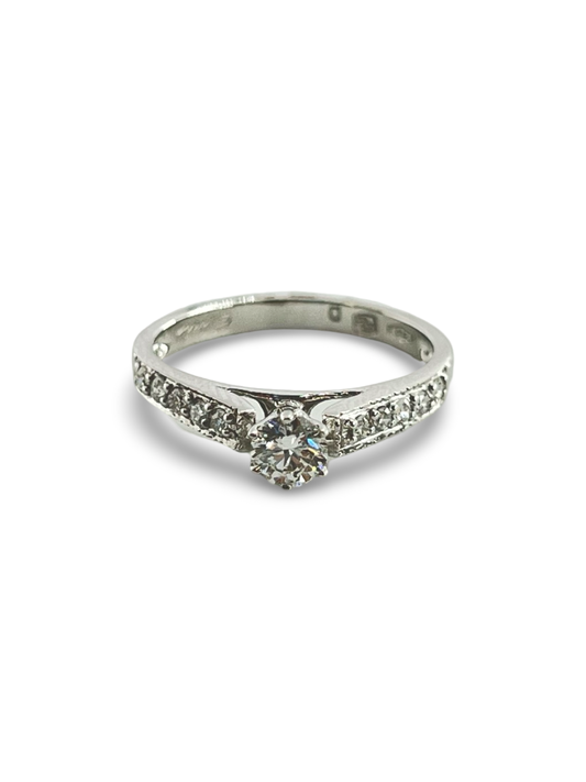 Découvrez notre superbe bague solitaire en or blanc, sertie d’un diamant naturel rond de 0,33 ct, accompagné de dix éclats scintillants de 0,03 ct chacun. Élégante et intemporelle, cette bague est le symbole parfait de l’amour et du raffinement. Idéale pour une demande en mariage, un anniversaire ou toute occasion spéciale, elle sublimera chaque instant. Offrez un bijou d’exception alliant éclat et finesse.