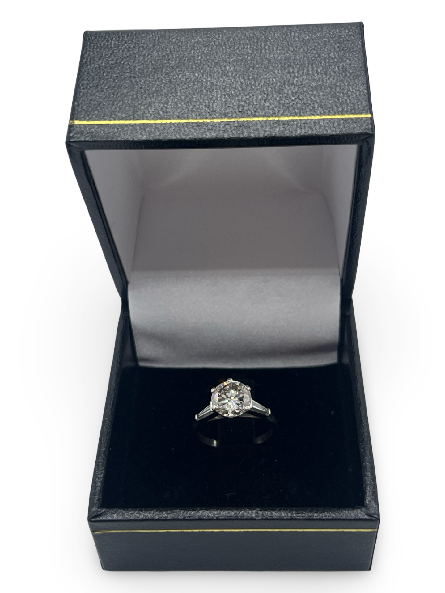 Cette bague solitaire en or blanc est sublimée par un diamant naturel taillé en rond de 1,92 ct, d'une qualité I-SI2, et accompagnée de deux diamants taillés en taper. Un écrin raffiné complète parfaitement cette pièce précieuse, idéale pour marquer un moment unique.







